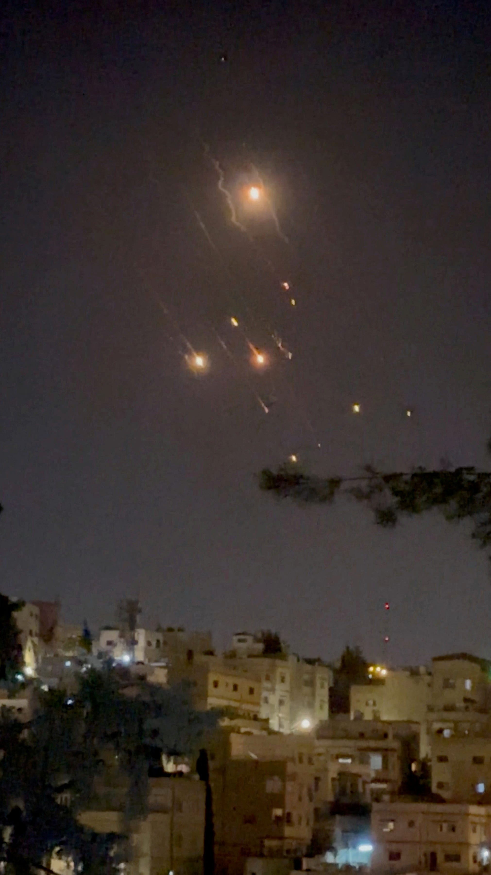 Objects are seen in the sky over Amman after Iran launched drones towards Israel, in Amman, Jordan April 14, 2024, in this screen grab obtained from a social media video. Video Obtained by REUTERS/via REUTERS THIS IMAGE HAS BEEN SUPPLIED BY A THIRD PARTY.
