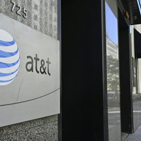 An AT&T telecommunication logo is seen at the entrance of a building in Washington, D.C. on June 11, 2019.