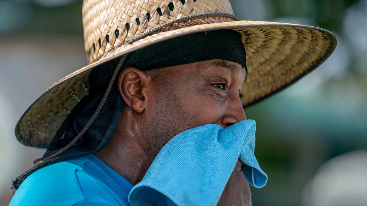 City worker Glen Peterson wipes the sweat from his face as the feel like temperature exceeded 100 degrees while working with a crew on June 28, 2023 in Lake Worth Beach, Florida.