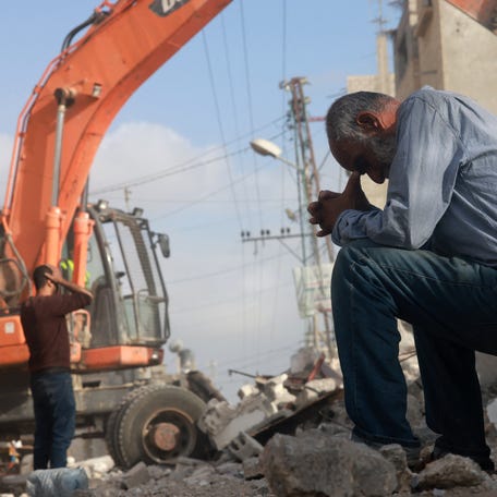 A Palestinian man wait for news of his daughter as rescue workers search for survivors under the rubble of a building hit in an overnight Israeli bombing in Rafah, in the southern Gaza Strip, on April 21, 2024.