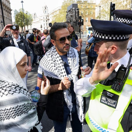 Pro-Palestinian supporters speak with a police officer during a protest in London, on April 13, 2024.