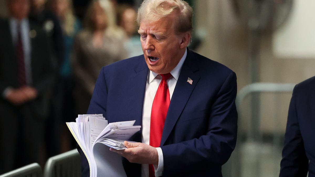 Former President Donald Trump displays a stack of papers while departing a New York City criminal court on April 23, 2024.