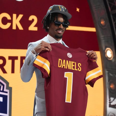 LSU Tigers quarterback Jayden Daniels poses after being selected by the Washington Commanders as the No. 2 pick in the first round of the 2024 NFL Draft at Campus Martius Park and Hart Plaza.