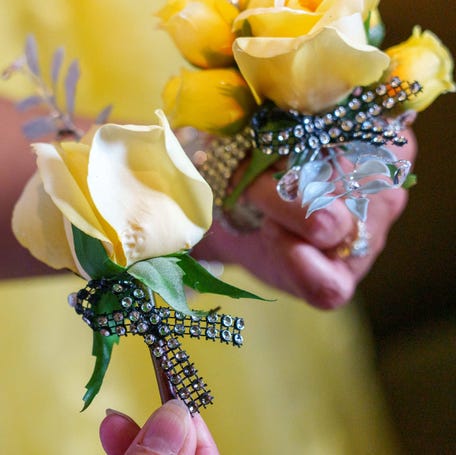 Charon Thompson shows the prom corsage and boutonniere Saturday, May 13, 2023, of her son, Cade, and his date to Avon High School's prom, Vivian Eagle. Both Cade and Eagle had and beat osteosarcoma, a cancer of the bone. The cancer ribbon color of osteosarcoma is yellow.