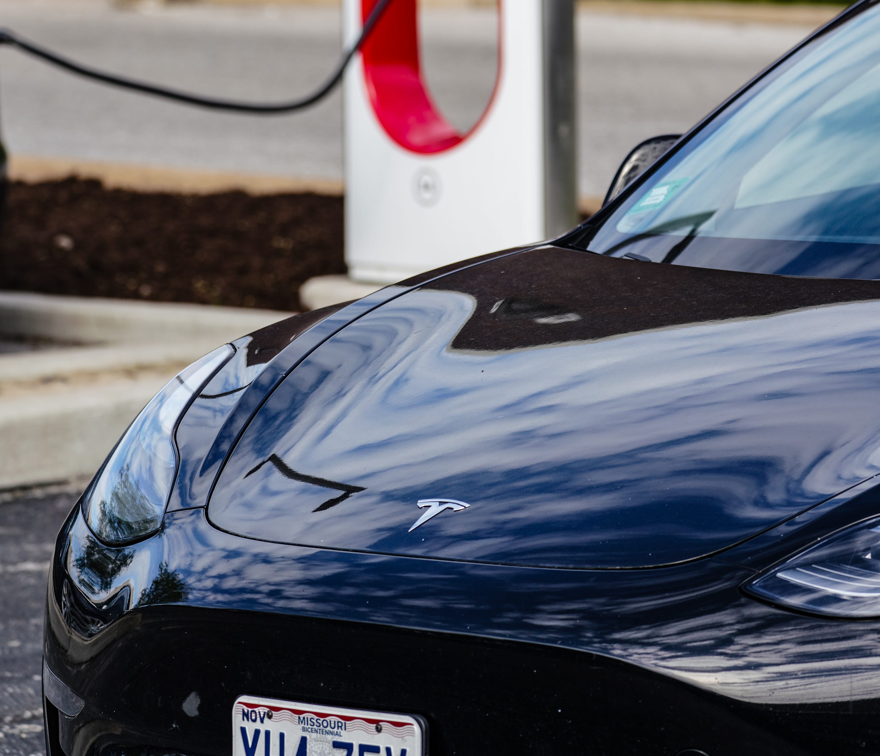 A Tesla sedan sits at a charging location in St. Louis, Missouri, among other charging Teslas.