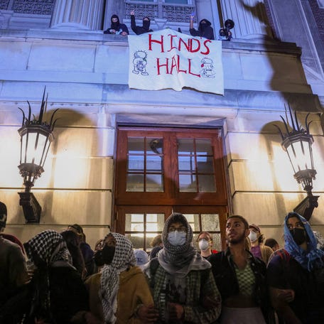 Protesters link arms outside Hamilton Hall barricading students inside the building at Columbia University in New York City on April 30, 2024.
