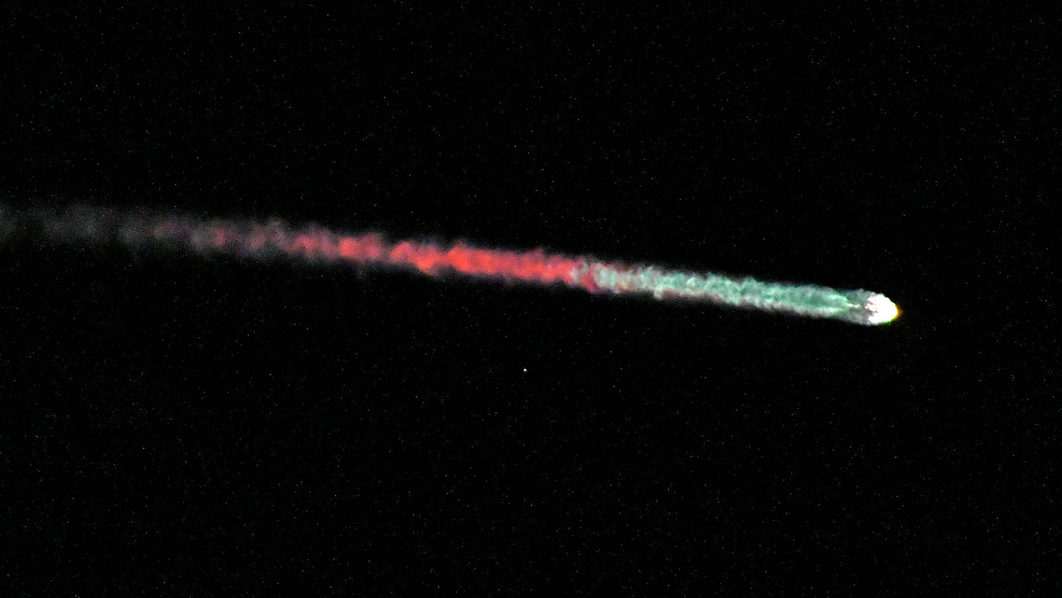 SpaceX Falcon 9 streaks colorfully across darkened sky Thursday night