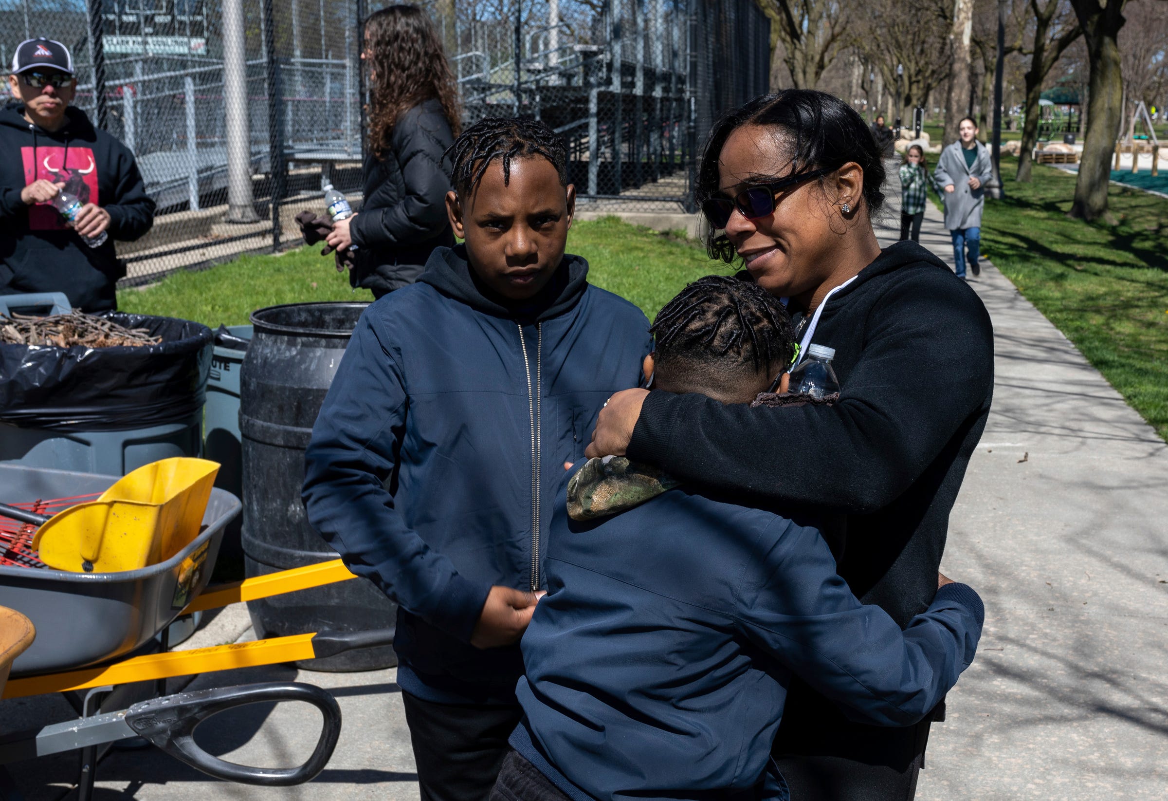Dessinae Houston, an employee with the Housing & Revitalization Department at the City of Detroit, hugs her children after helping clean Clark Park in southwest Detroit on Sat., April 13, 2024.
