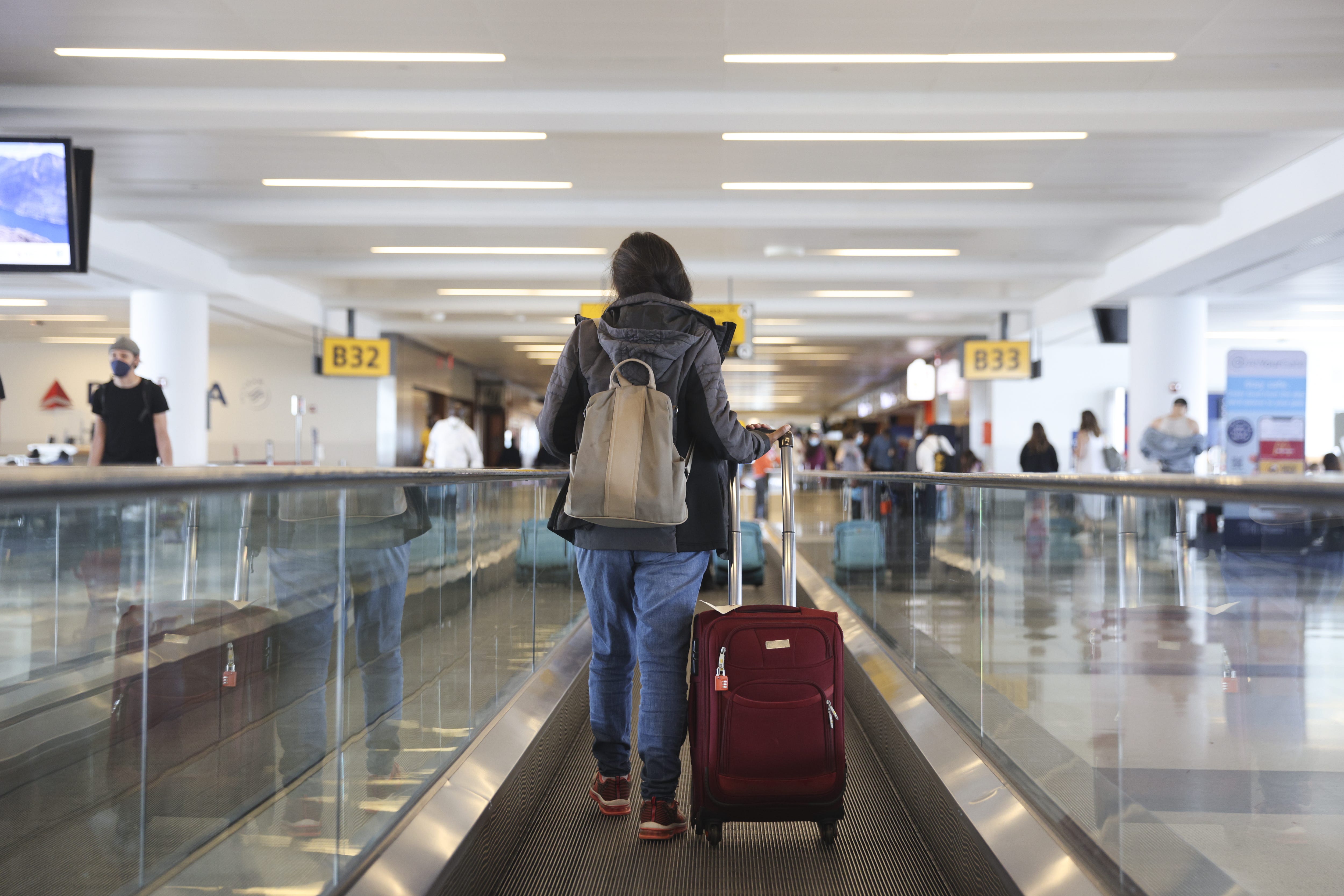 A traveler walks on a moving walkway in Terminal 4 at John F. Kennedy International Airport (JFK) in New York on March 26, 2021.