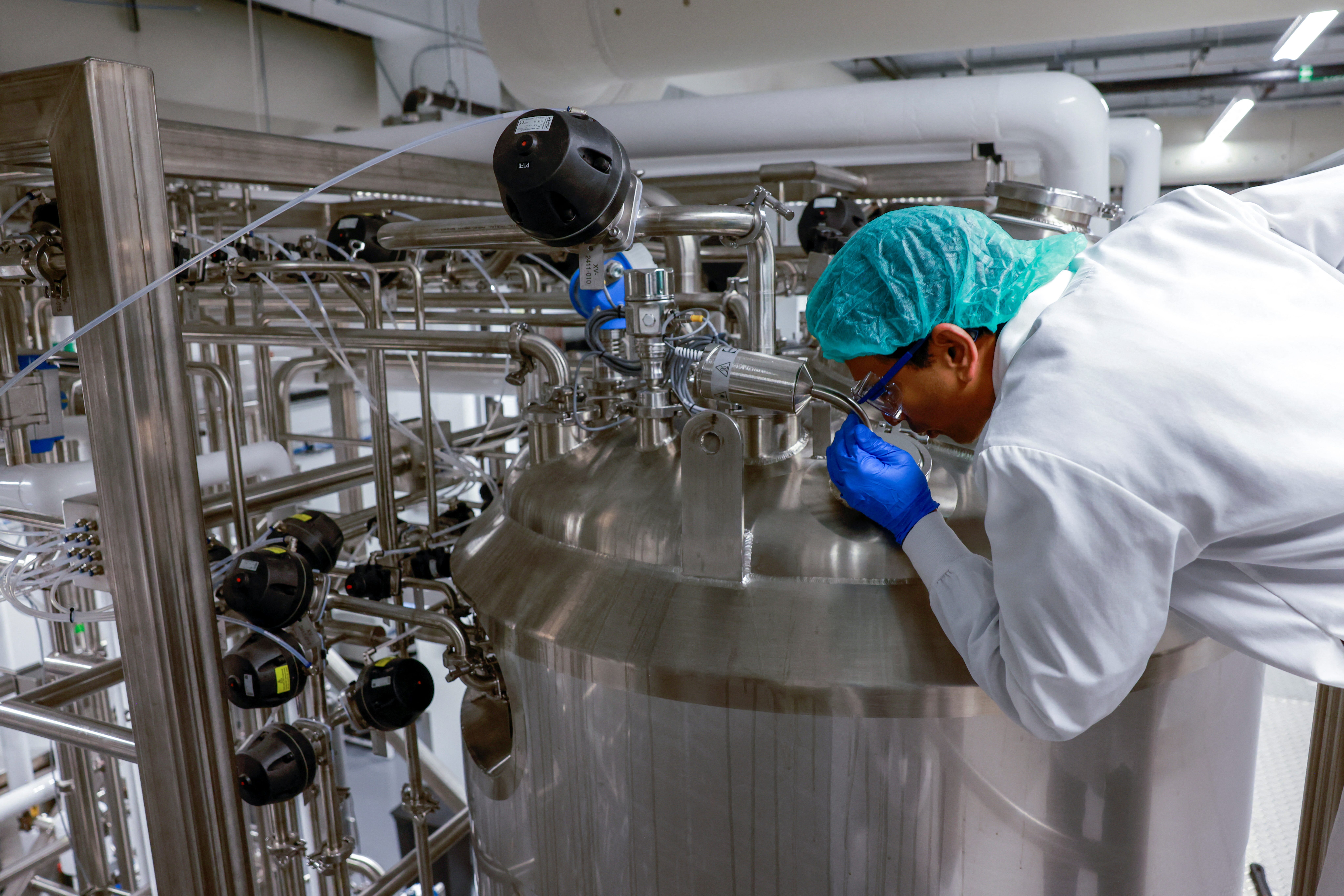 Upside founder & CEO Uma Valeti peers into one of the cultivation tanks at the Upside Foods plant in Emeryville, California, , where lab-grown meat is cultivated, on January 11, 2023.