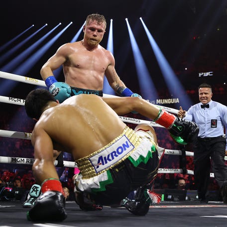 Canelo Alvarez knocks down Jaime Munguia in their super middleweight championship title fight.