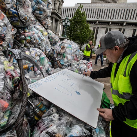 Peter Baker, owner of Can Bottle Return in Buffalo, writes a sign on top of bottles and cans that are not presently eligible for deposit redemption outside the New York State Capitol May 6, 2024. Baker joined dozens of bottle collectors and others from the redemption industry to call for the passage of bills that would modernize the New York State Bottle Bill. Among the changes in the law that bottle collectors, owners of redemption centers, and environmental groups want to see is the deposit fee raised to 10 cents from the present five cents per bottle. They also want to see an increase in the number of containers that are eligible for deposit.