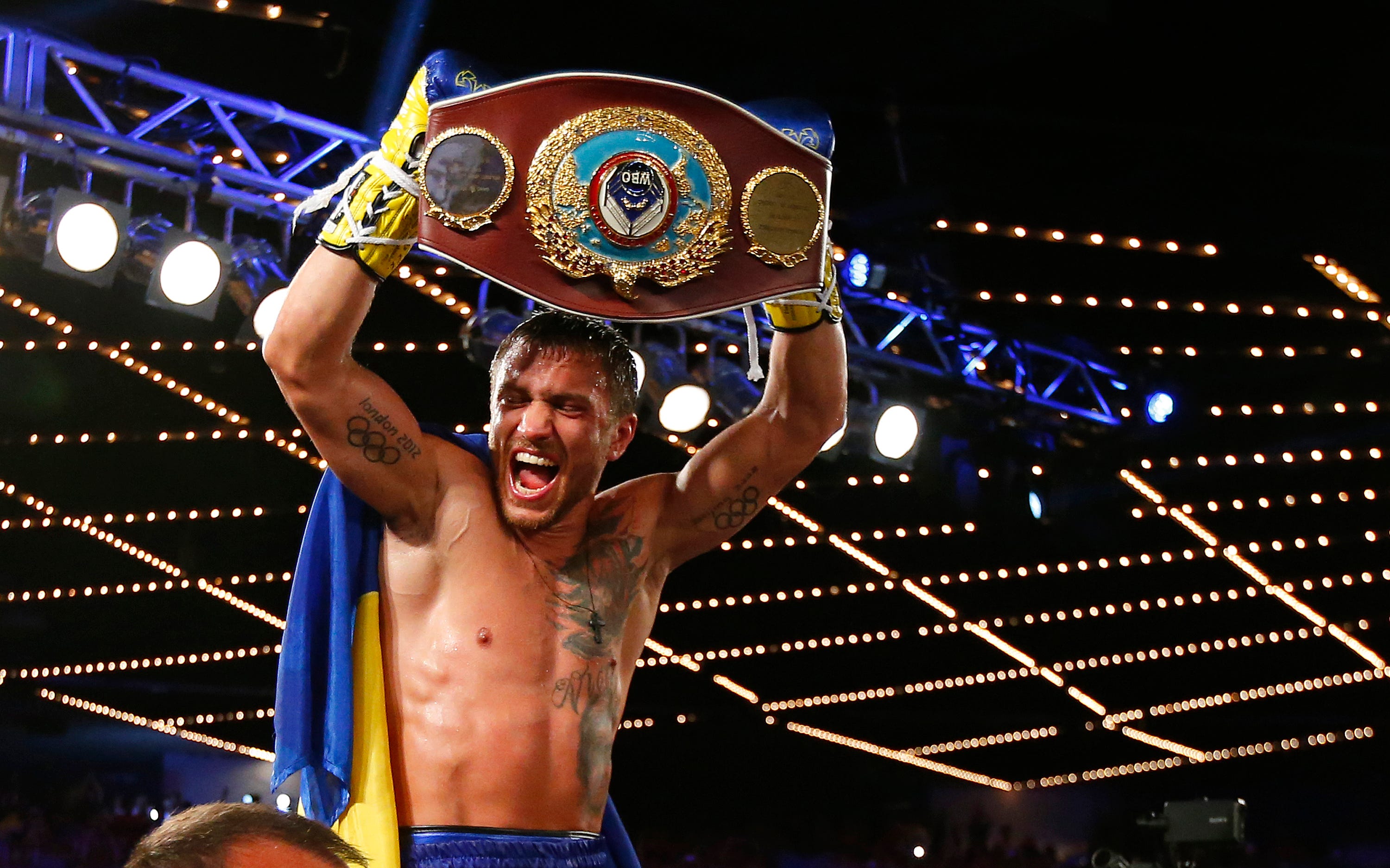 Vasiliy Lomachenko holds up a belt after a win in 2016.