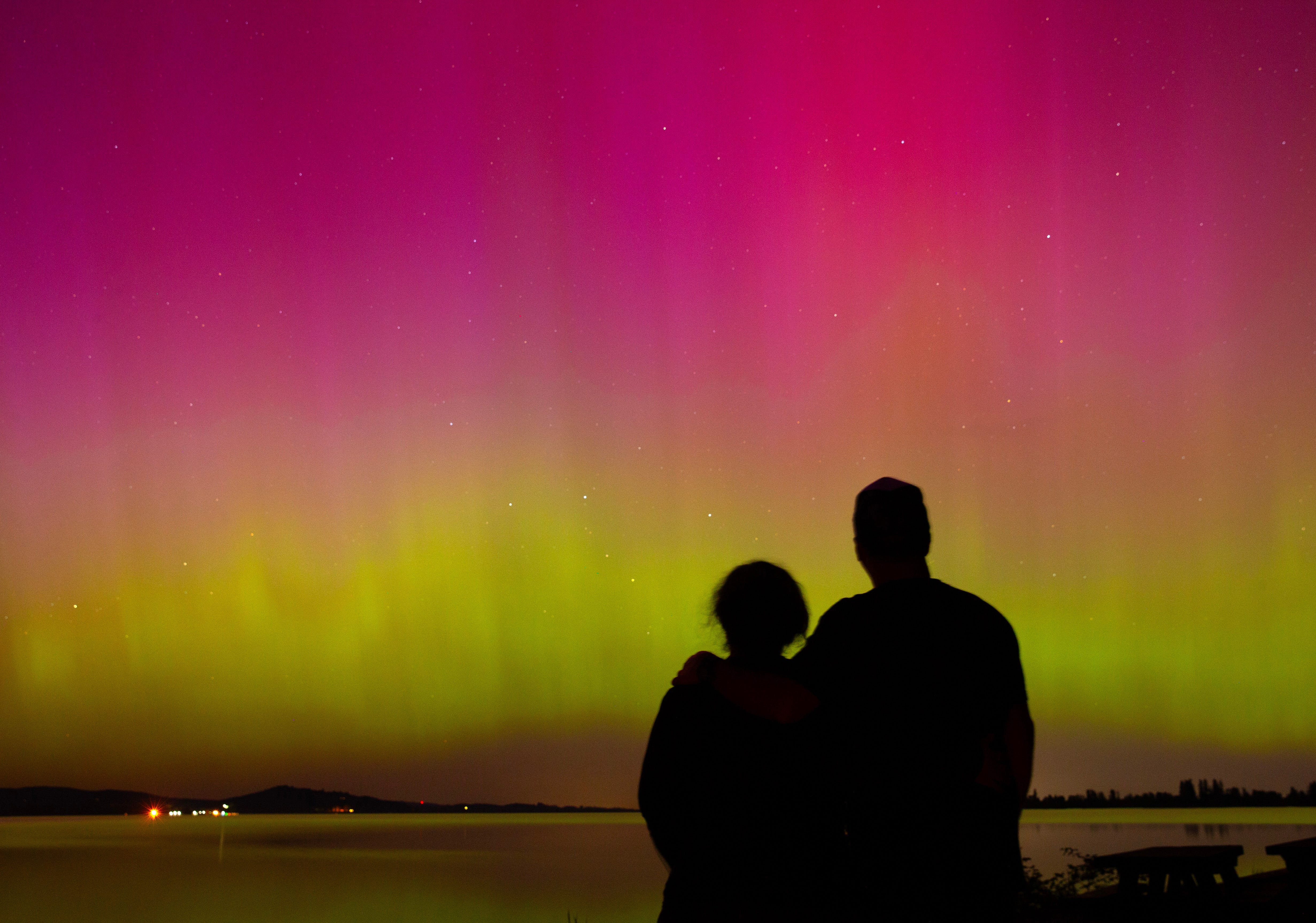 Two people watch the northern lights Friday night from Perkins Peninsula Park on the shores of Fern Ridge reservoir west of Eugene, Oregon.