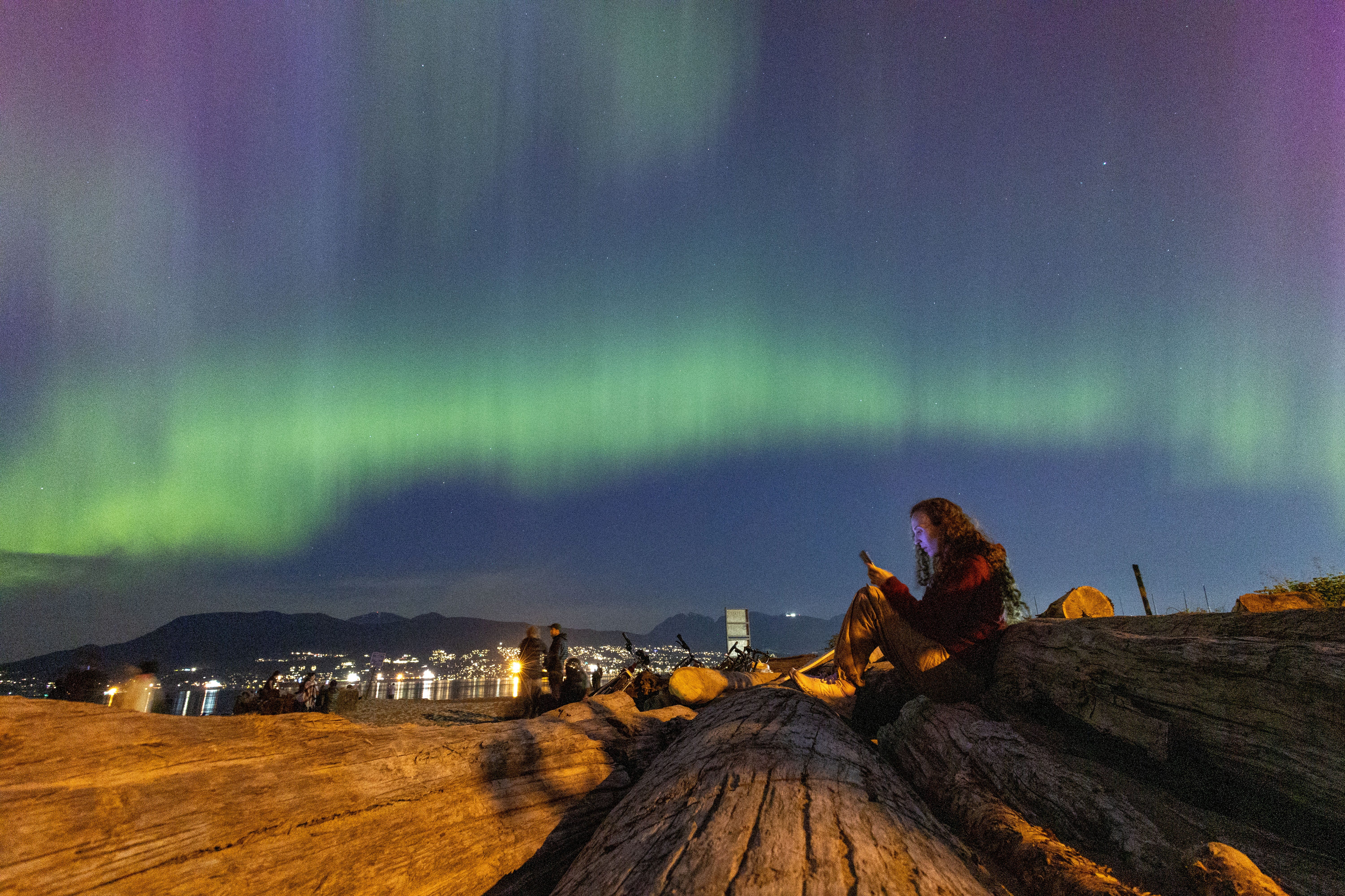 The aurora borealis, also known as the "northern lights", caused by a coronal mass ejection on the Sun, illuminates the sky Friday night over Jericho Beach in Vancouver, British Columbia, Canada.