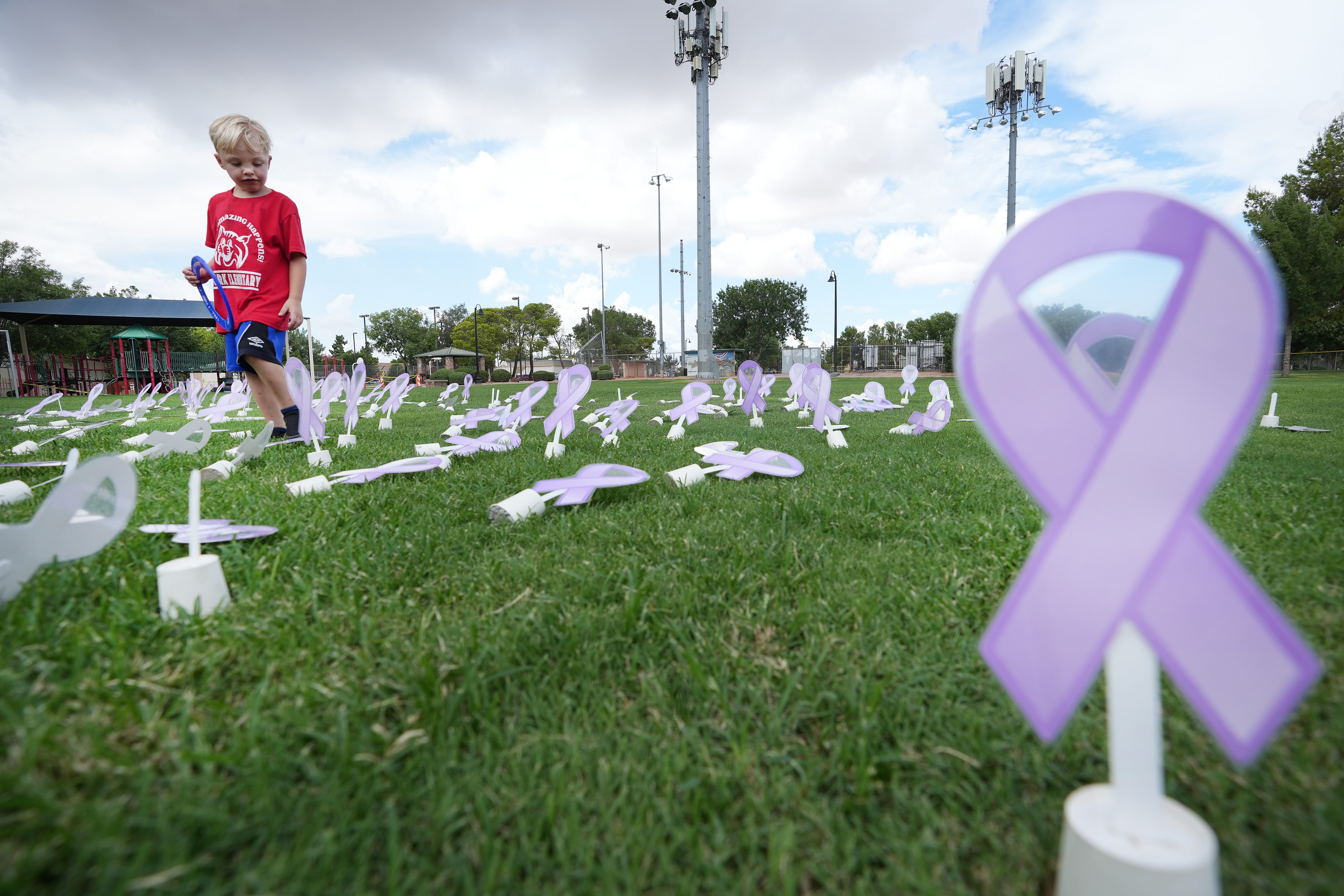 Johnny Christophersen, 7, who lost his older brother Tristan, 16, in 2021, walks through a display honoring teen lives lost to drug overdoses during an event at Founders Park in Queen Creek on Aug. 20, 2022, to raise awareness for how fentanyl is causing overdose deaths for Arizona kids.    Fentanyl Event 10