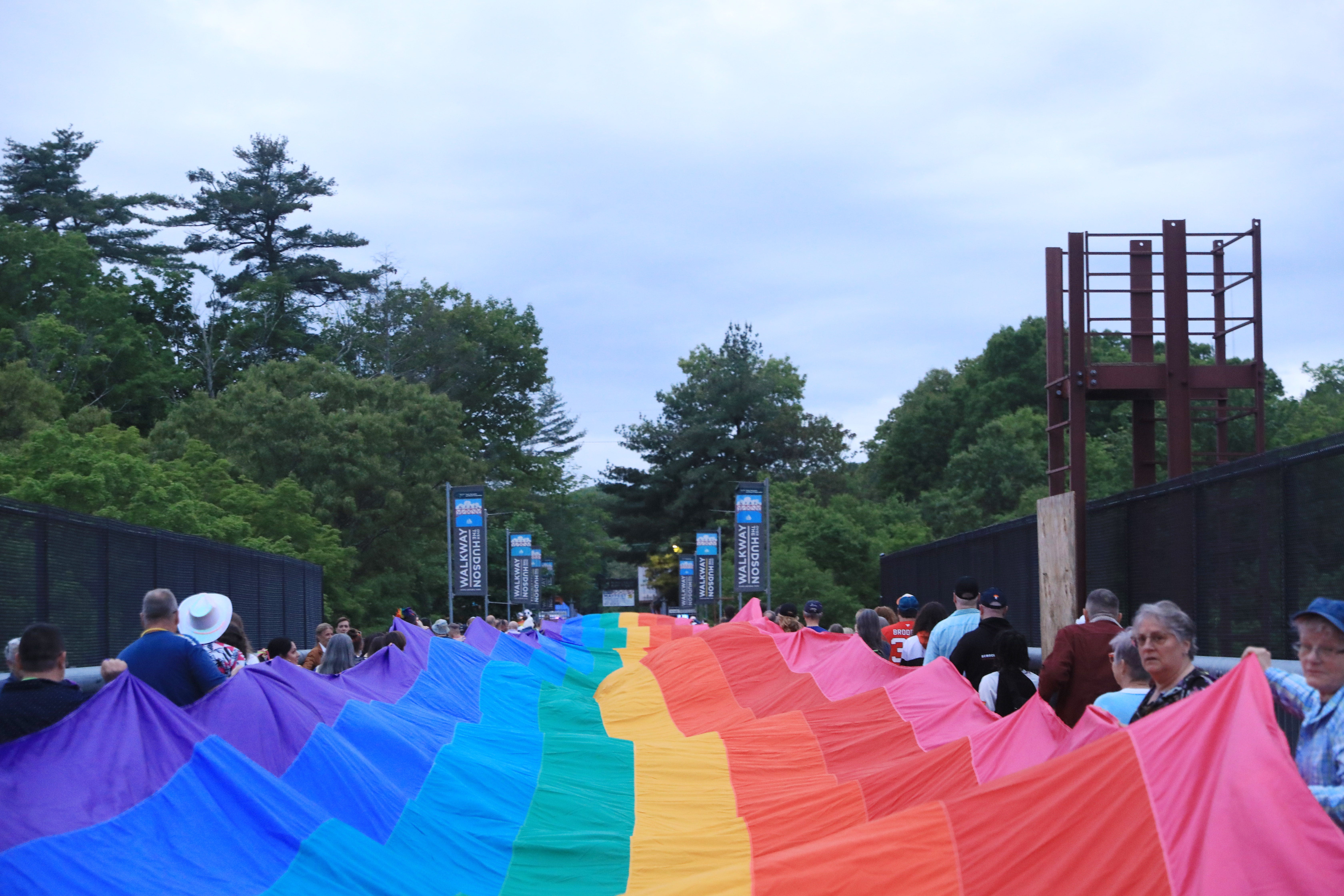 Participants carry a giant pride flag during the Pride in the Sky event at the Walkway Over the Hudson State Historic Park in Highland on May 17, 2024.