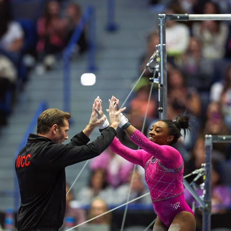 US gymnast Simone Biles (R) is congratulated by coach Laurent Landi after competing in the uneven bars event during the Core Hydration Classic at XL Center in Hartford, Connecticut, on May 18, 2024. (Photo by Charly TRIBALLEAU / AFP) (Photo by CHARLY TRIBALLEAU/AFP via Getty Images)