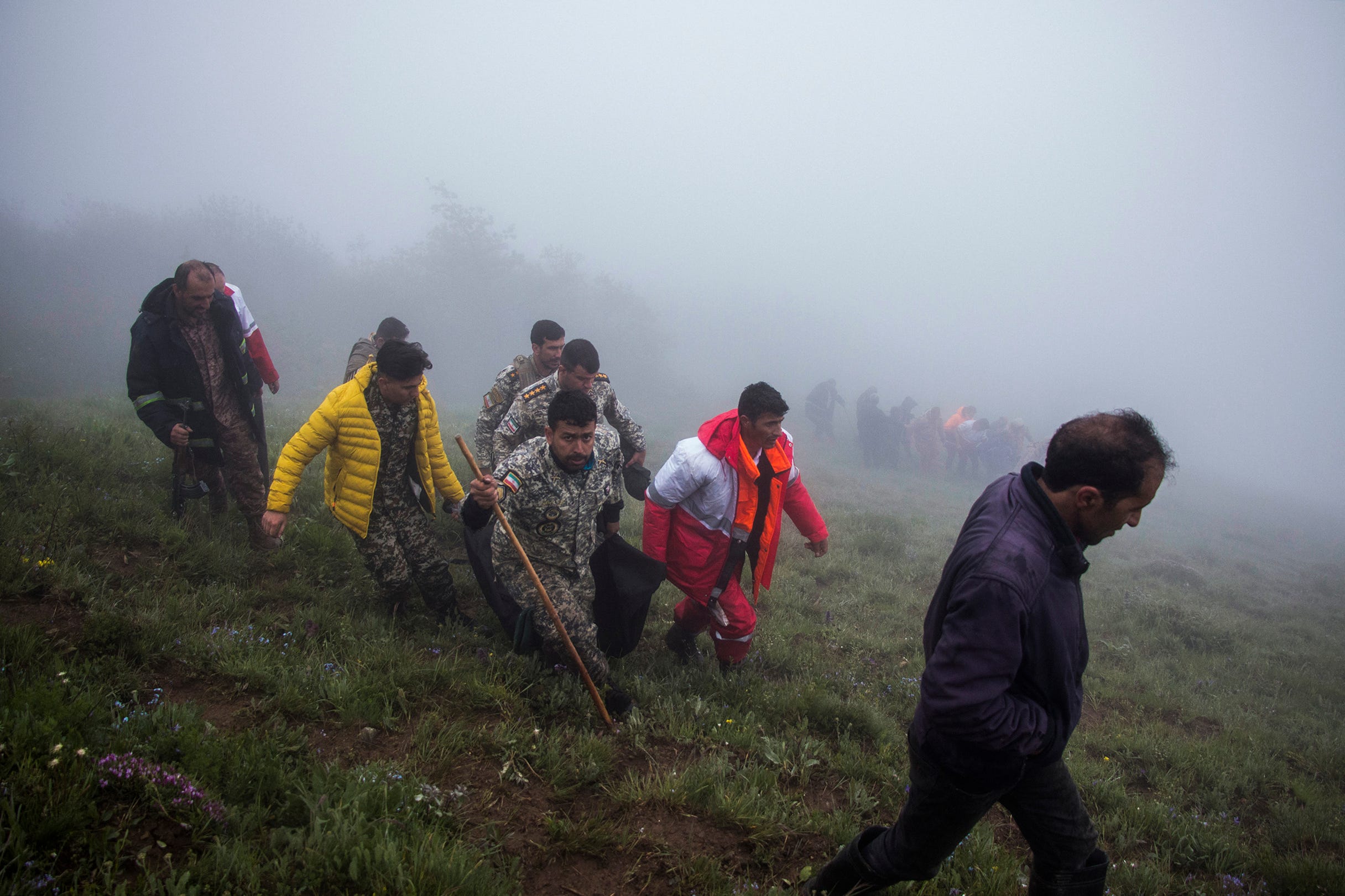 Rescue team members carry the body of a victim at the crash site of a helicopter carrying Iranian President Ebrahim Raisi in Varzaghan, in northwestern Iran, on May 20, 2024. Iranian President Ebrahim Raisi was declared dead on May 20 after rescue teams found his crashed helicopter in a fog-shrouded western mountain region, sparking mourning in the Islamic republic.