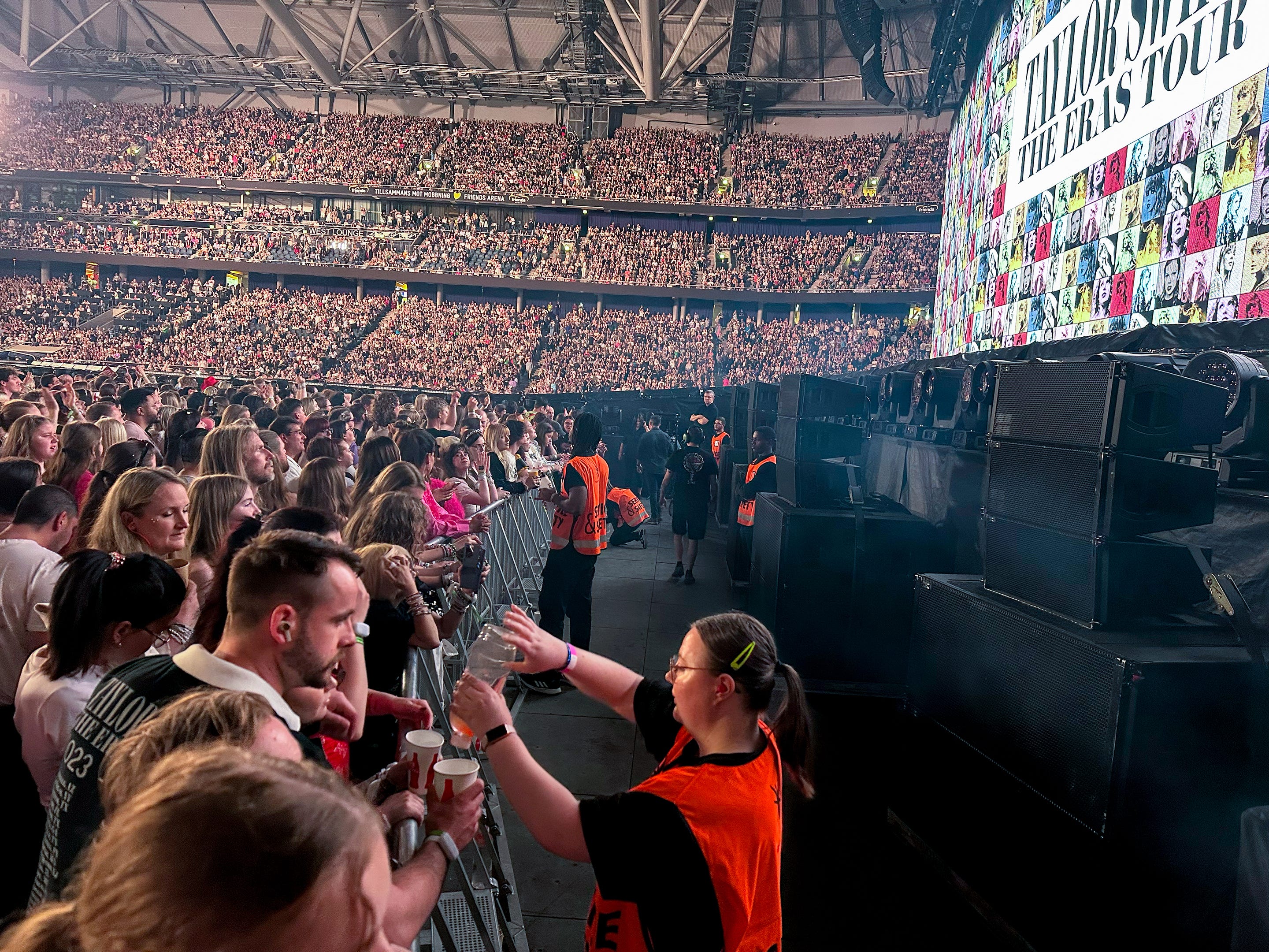 Security guard pours water for fan ahead of Taylor Swift's Eras Tour in Stockholm, Sweden, on Sunday, May 19, 2024.