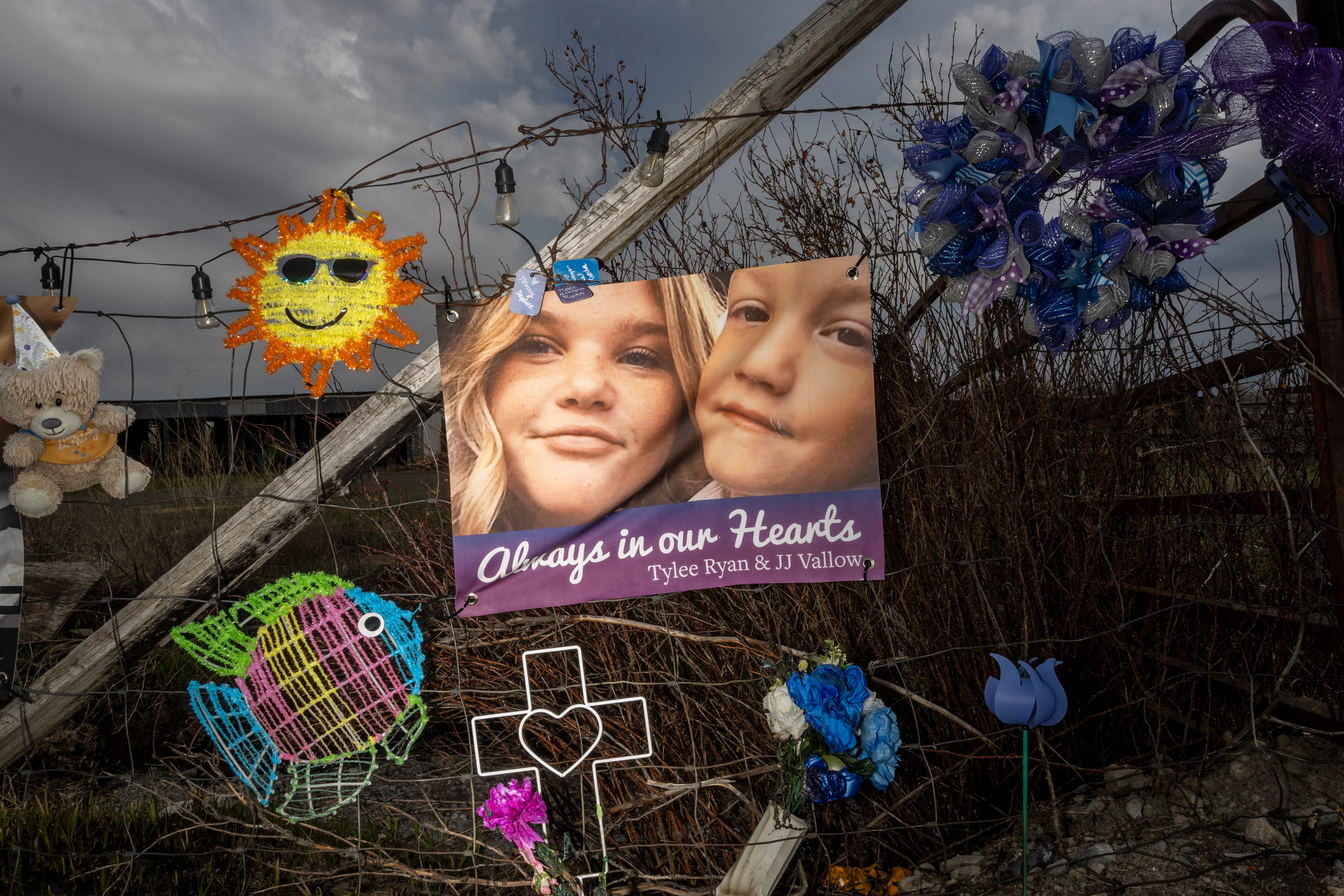 A banner with photos of Tylee Ryan and her brother J.J. Vallow is seen on a fence set up as a memorial near where her body was found on May 10, 2023, in Rexburg, Idaho. Lori Vallow Daybell faces charges of murder, conspiracy, and grand theft in connection to the deaths of two of her children â€