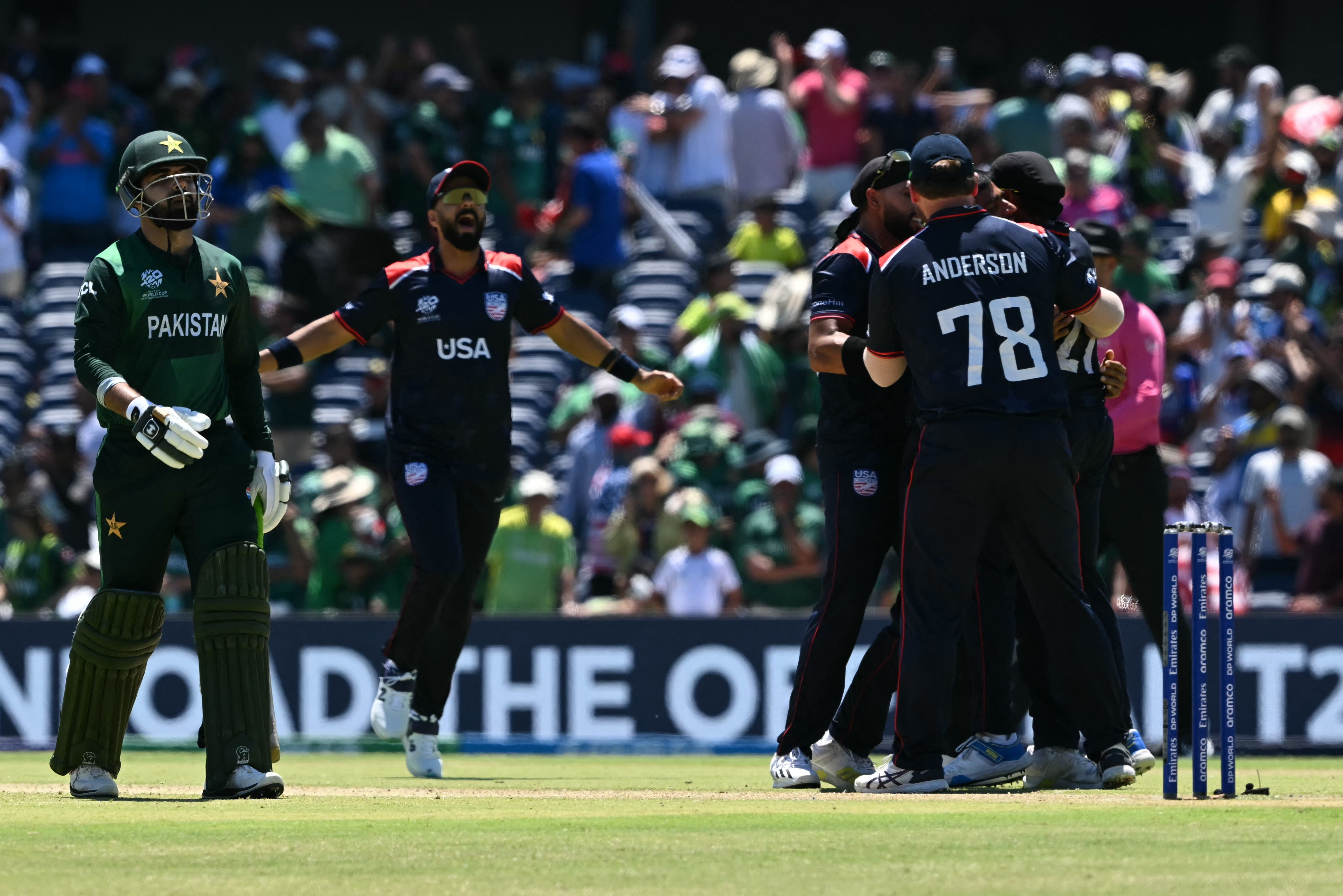 USA's players celebrate after winning the game in a super over as Pakistan's Shadab Khan (L) walks off during the ICC men's Twenty20 World Cup 2024 group A cricket match between the USA and Pakistan at the Grand Prairie Cricket Stadium in Grand Prairie, Texas, on June 6, 2024.