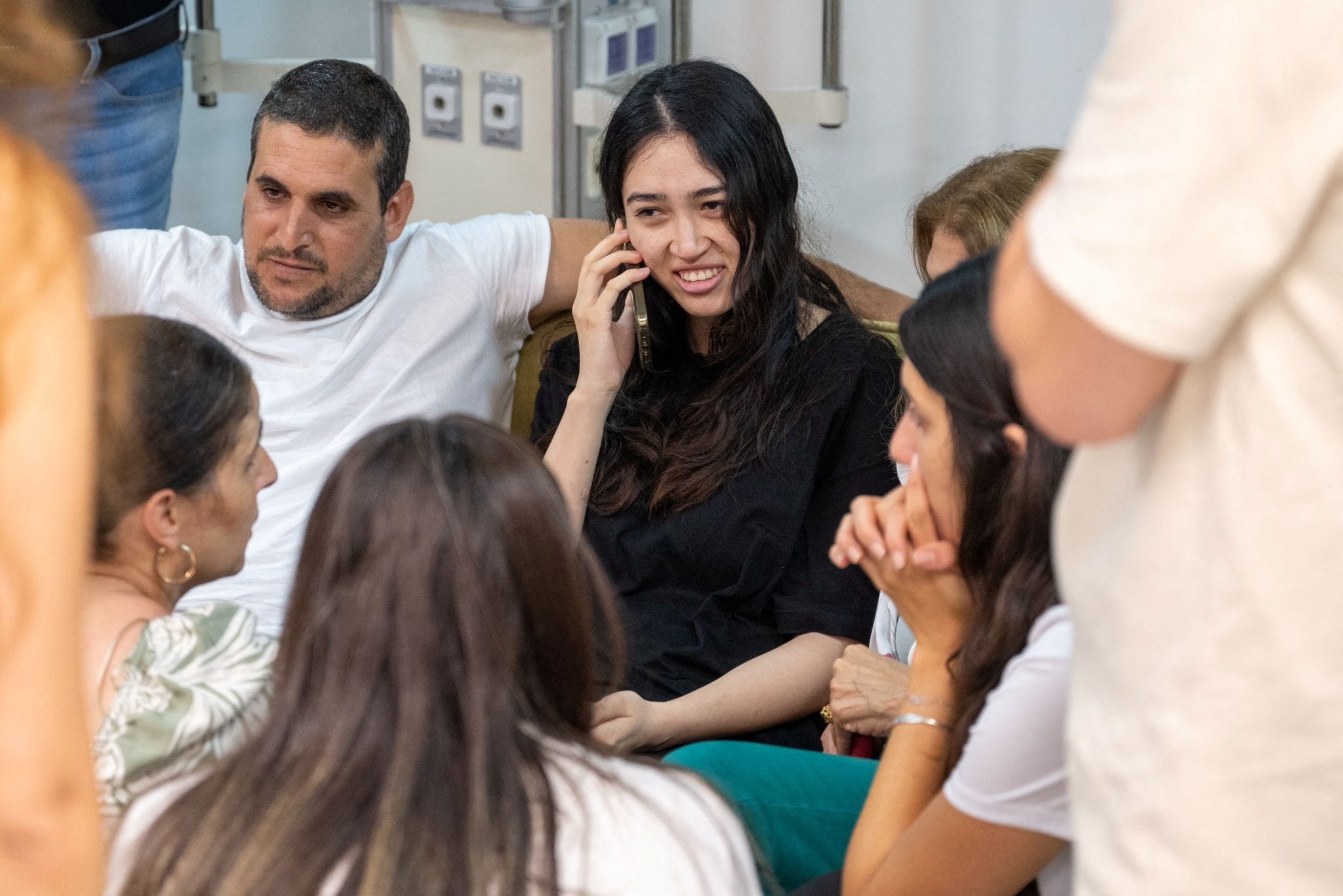 Noa Argamani, a rescued hostage speaks on the phone surrounded by loved ones, after the military said that Israeli forces have rescued four hostages alive from the central Gaza Strip, in Ramat Gan, Israel, in this handout image obtained by Reuters on June 8, 2024.