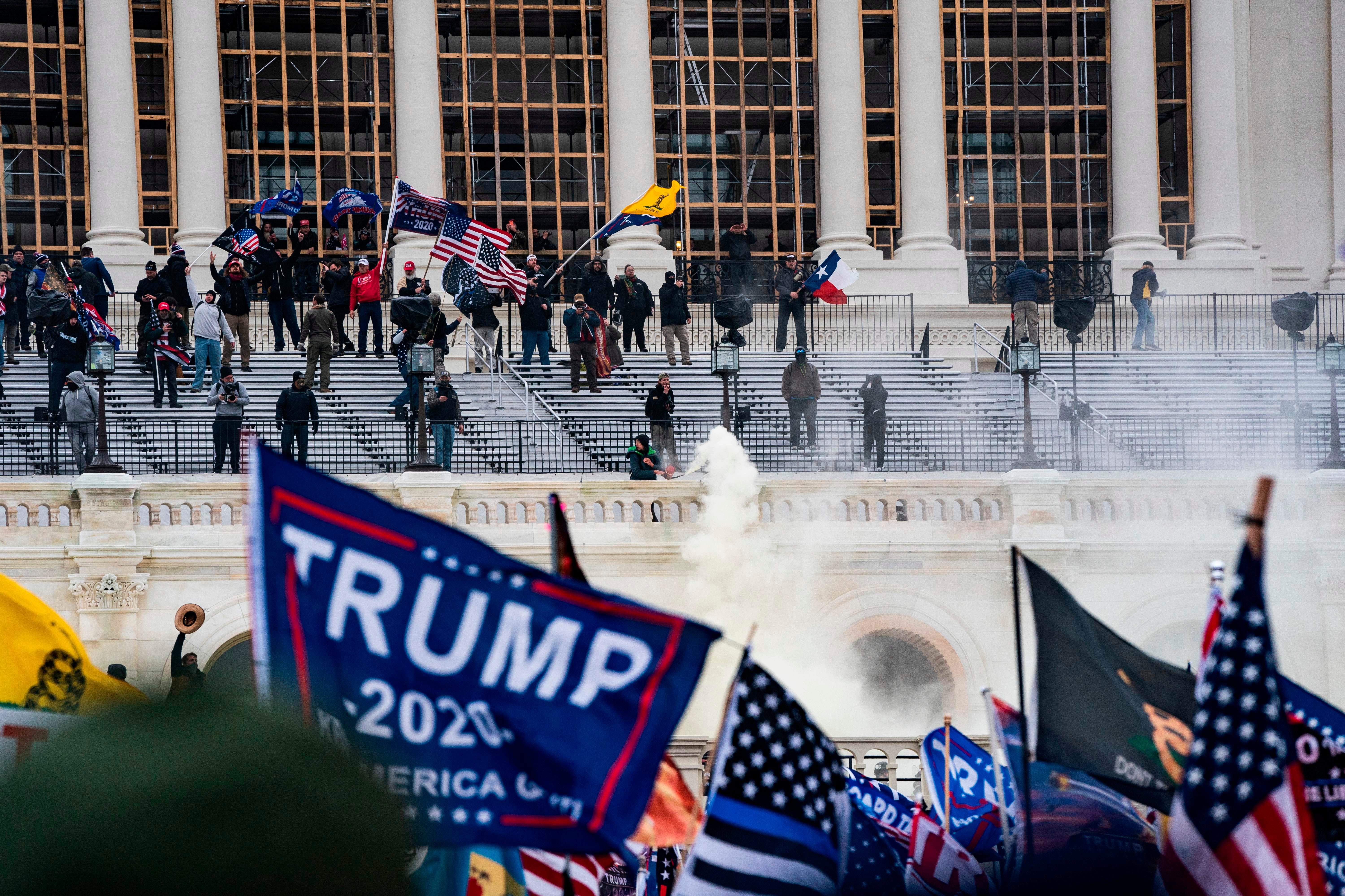Supporters of US President Donald Trump clash with the US Capitol police during a riot at the US Capitol on January 6, 2021, in Washington, DC. - Donald Trump's supporters stormed a session of Congress held January 6 to certify Joe Biden's election win, triggering unprecedented chaos and violence at the heart of American democracy and accusations the president was attempting a coup. (Photo by ALEX EDELMAN / AFP) (Photo by ALEX EDELMAN/AFP via Getty Images)