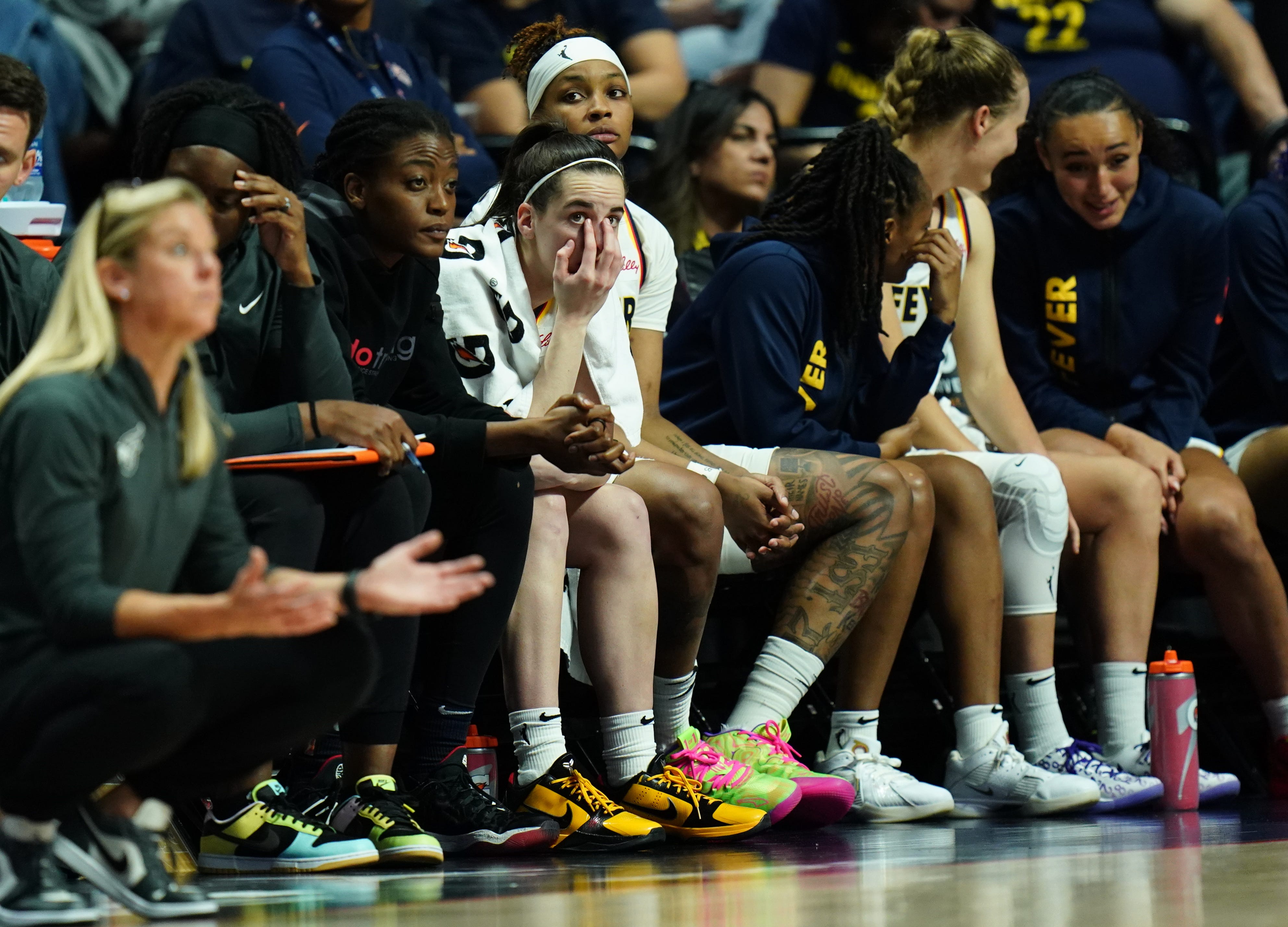 Indiana Fever guard Caitlin Clark (22) on the bench with her teammates in the second half as they take on the Connecticut Sun at Mohegan Sun Arena.