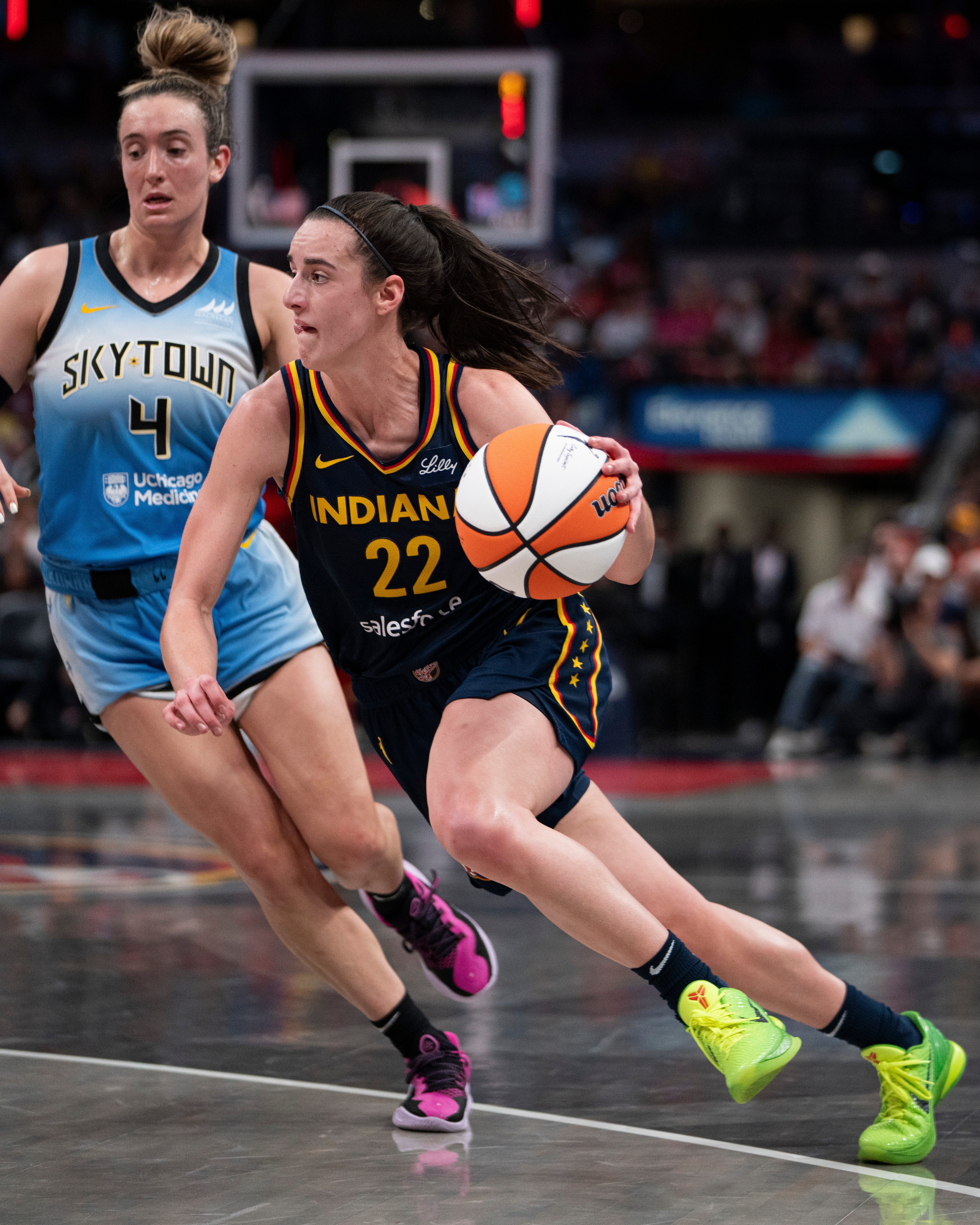 Caitlin Clark (22) dribbles around the Chicago Sky' Marina Mabrey (4) on Sunday at Gainbridge Fieldhouse in Indianapolis.