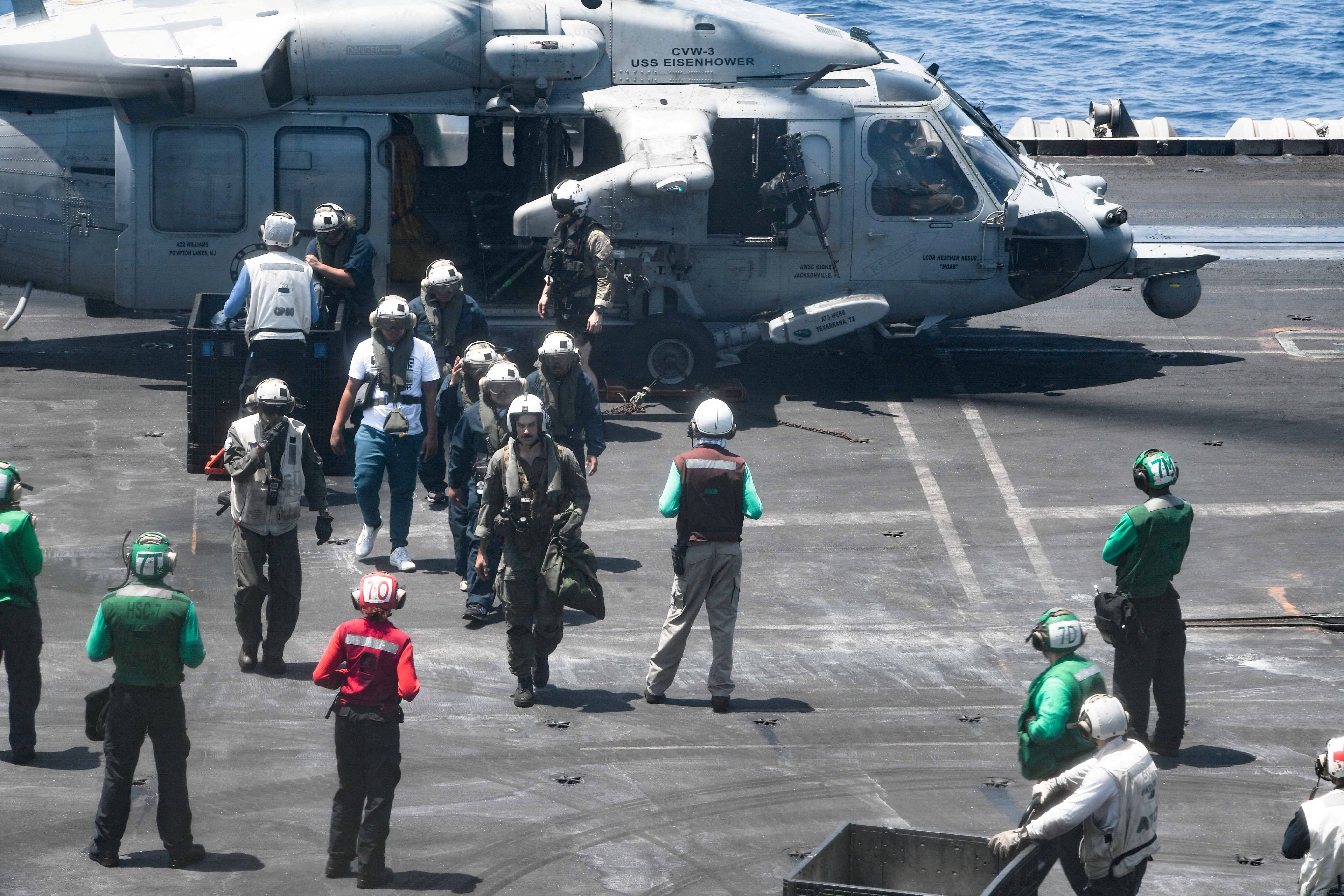 FILE PHOTO: Sailors from the Dwight D. Eisenhower Carrier Strike Group assist distressed mariners rescued from the Liberian-flagged, Greek-owned bulk carrier M/V Tutor that was attacked by Houthis, in the Red Sea, June 15, 2024. Authorities confirmed the ship has sunk.