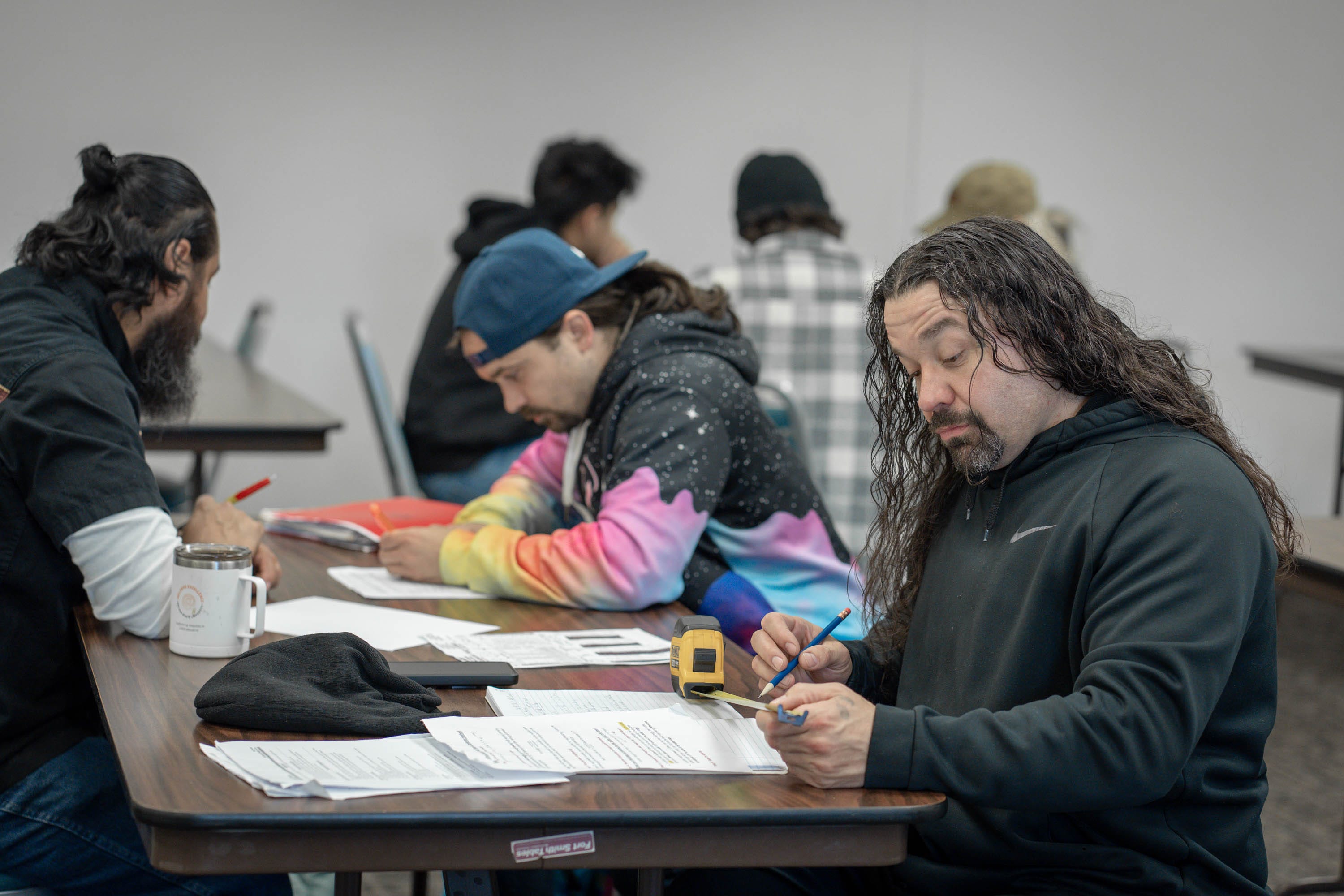 Keith Perkins, foreground, works through an algorithm for calculating ladder rung spacing in math for welders class at Linn-Benton Community College in Oregon.