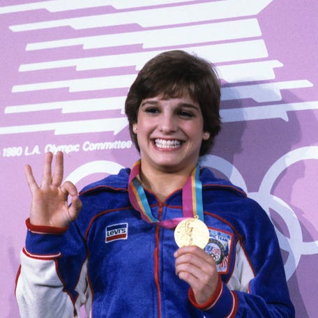 Mary Lou Retton holds one of her gold medals at Pauley Pavilion during the 1984 Los Angeles Olympics.