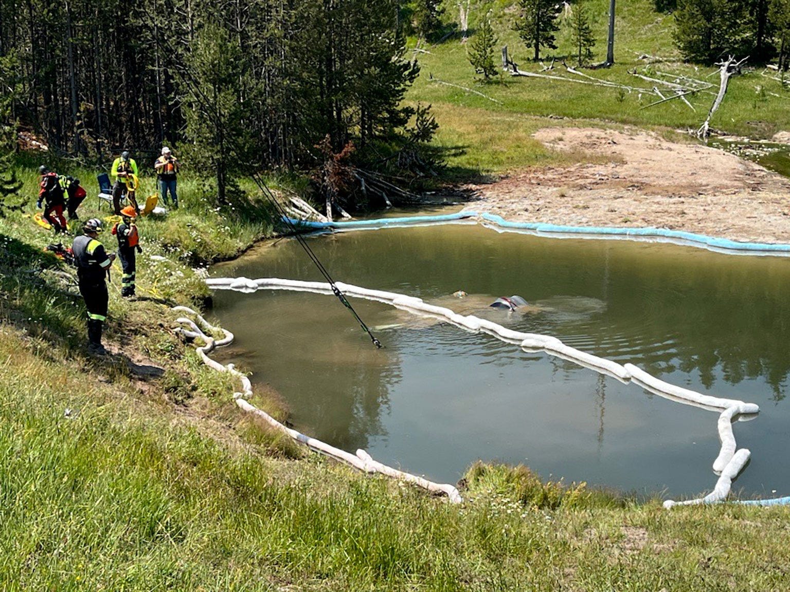 Rescuers work as a car fallen into a Semi-Centennial Geyser thermal feature being lifted at Yellowstone National Park, Wyoming, U.S., in this handout image released on July 12, 2024.