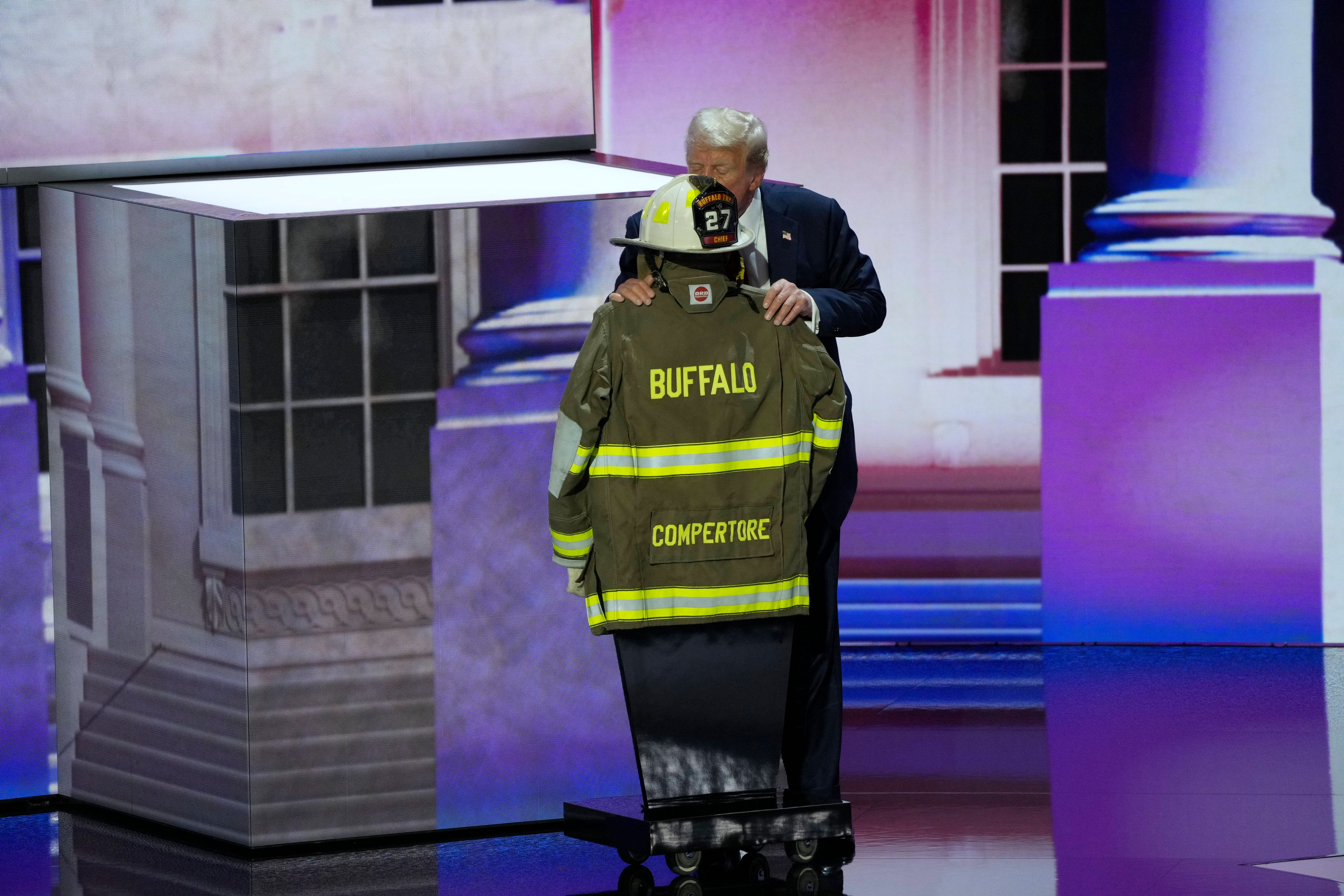 July 18, 2024; Milwaukee, WI, USA; Republican presidential nominee Donald J. Trump kisses the uniform of former fire fighter Corey Comperatore, who was killed at the Butler rally, before delivering his nomination acceptance speech during the final day of the Republican National Convention at the Fiserv Forum. The final day of the RNC featured a keynote address by Republican presidential nominee Donald Trump. Mandatory Credit: Mike De Sisti-USA TODAY
