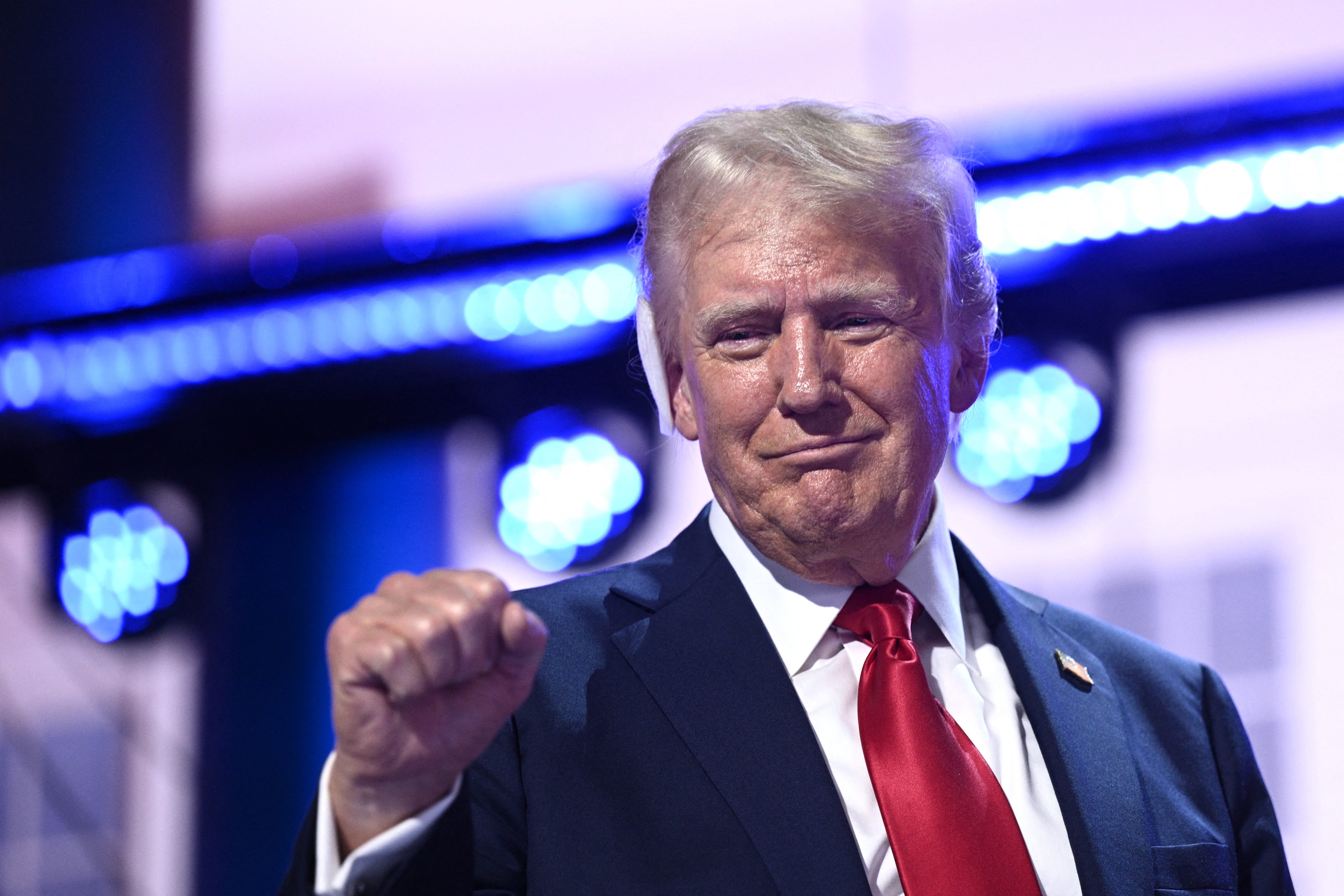 US former President and 2024 Republican presidential candidate Donald Trump holds up a fist onstage during the last day of the 2024 Republican National Convention at the Fiserv Forum in Milwaukee, Wisconsin, on July 18, 2024. Donald Trump will get a hero's welcome Thursday as he accepts the Republican Party's nomination to run for US president in a speech capping a convention dominated by the recent attempt on his life. (Photo by Brendan SMIALOWSKI / AFP) (Photo by   BRENDAN SMIALOWSKI/AFP via Getty Images)