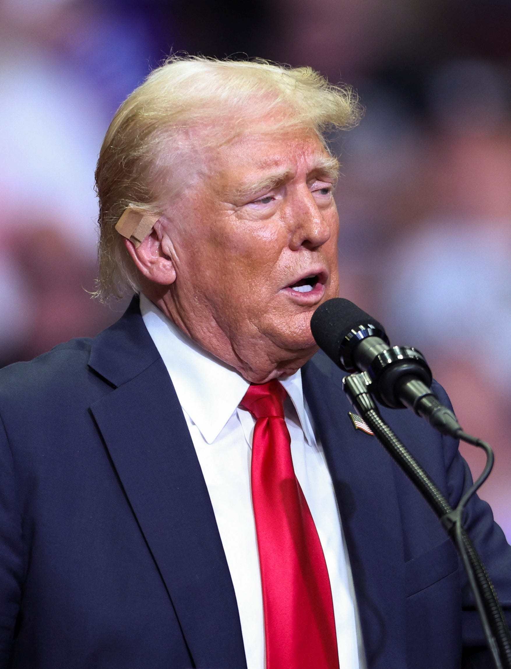 Republican presidential nominee and former U.S. President Donald Trump wears a flesh-colored bandage on his ear as he holds a campaign rally for the first time with his running mate, Republican vice presidential nominee U.S. Senator J.D. Vance (R-OH) in Grand Rapids, Michigan, U.S. July 20, 2024. REUTERS/Tom Brenner