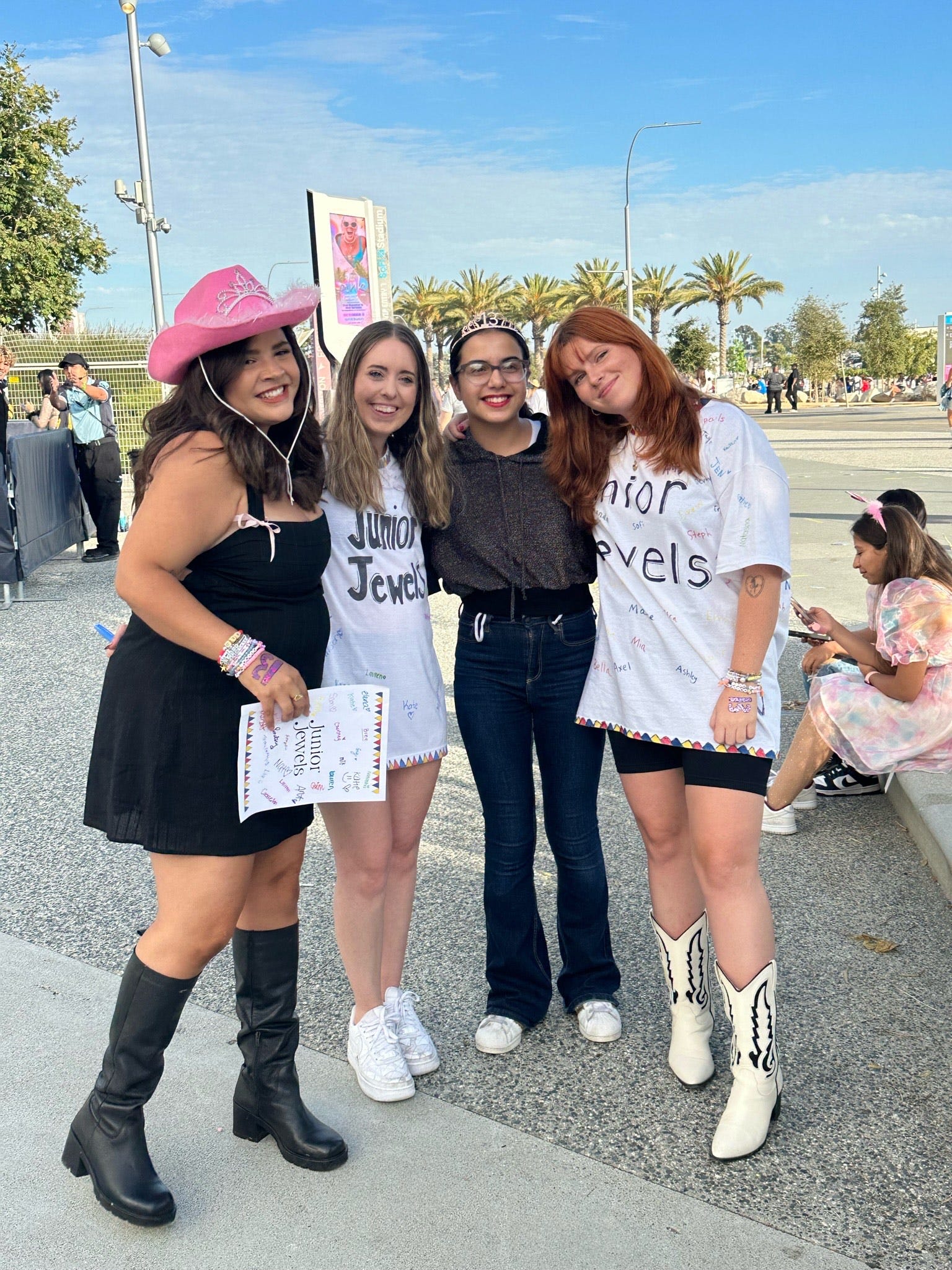 Channette Garay (far left), Courtney Johnston (second from left) and Angel Richards (far right) surprise a fan in Los Angeles with two free tickets to the Eras Tour.