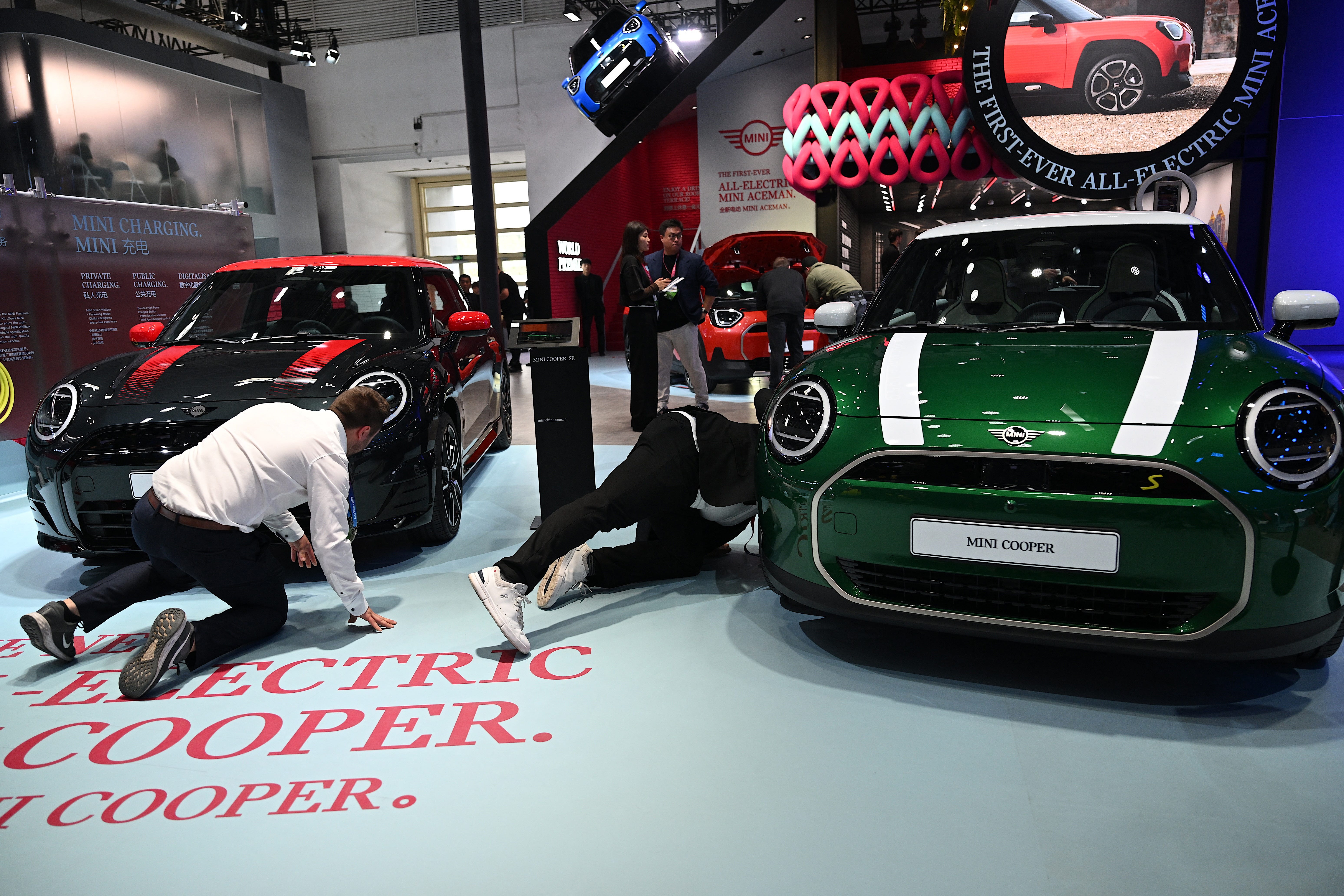 Staff members check the new all-electric Mini Cooper car at the Beijing Auto Show in Beijing on April 25, 2024. MINI was rated the highest mass market brand for customer satisfaction by the J.D. Power 2024 APEAL survey.