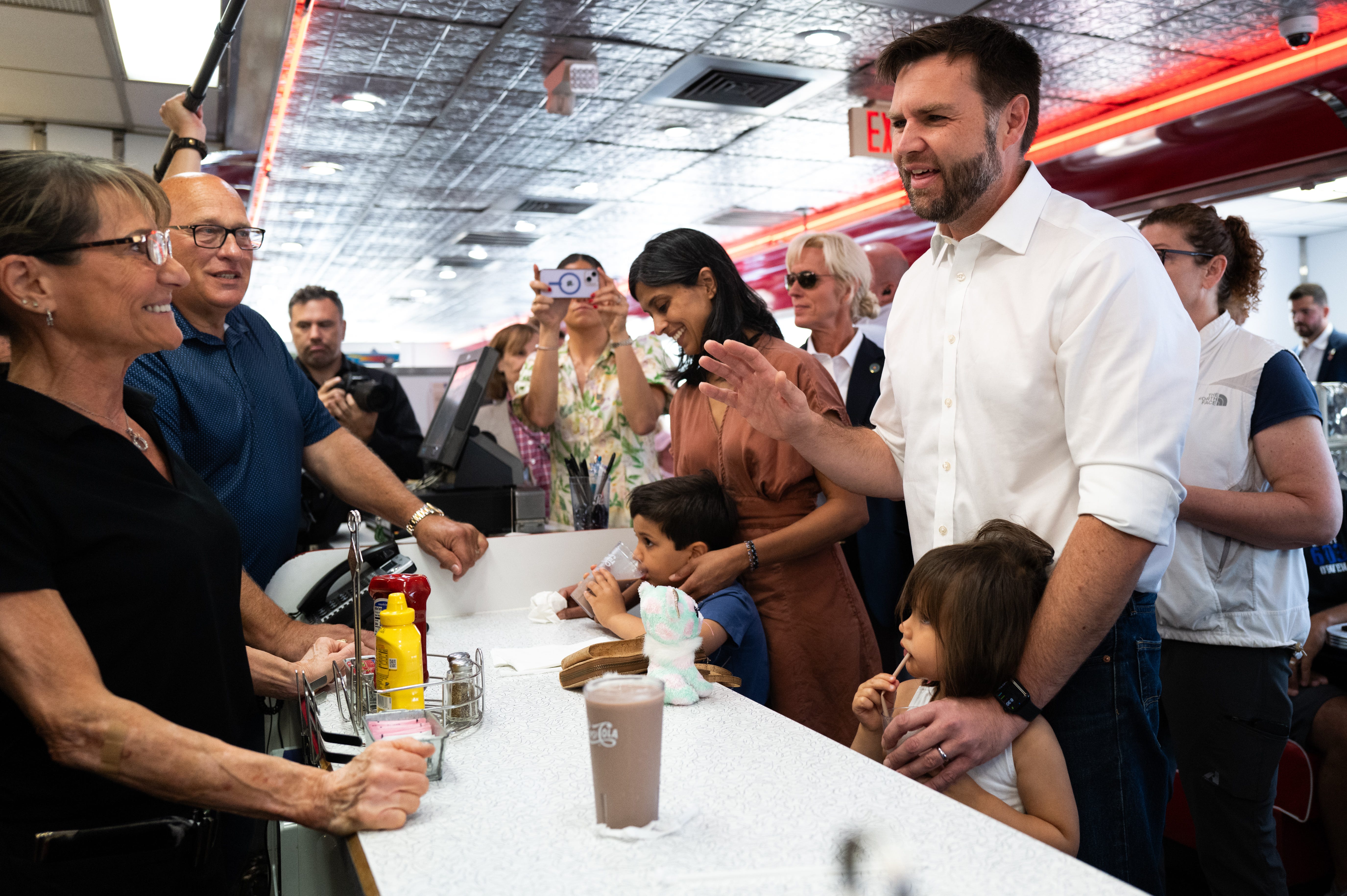 Republican vice presidential nominee JD Vance and his wife, Usha Chilukuri Vance, and kids greet supporters at a diner in St Cloud, Minn., on July 28, 2024.