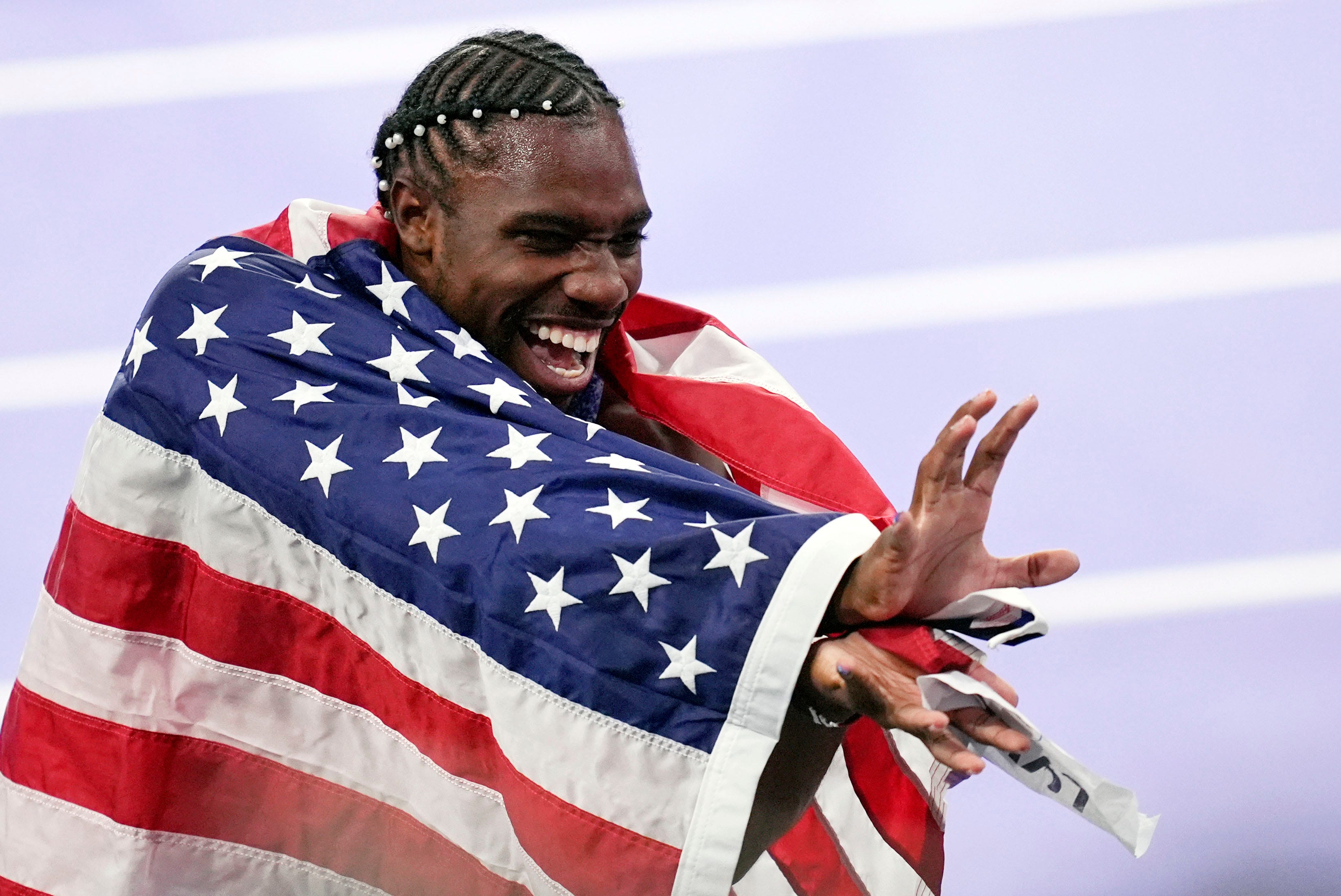 Noah Lyles celebrates after winning the men's 100-meter dash.