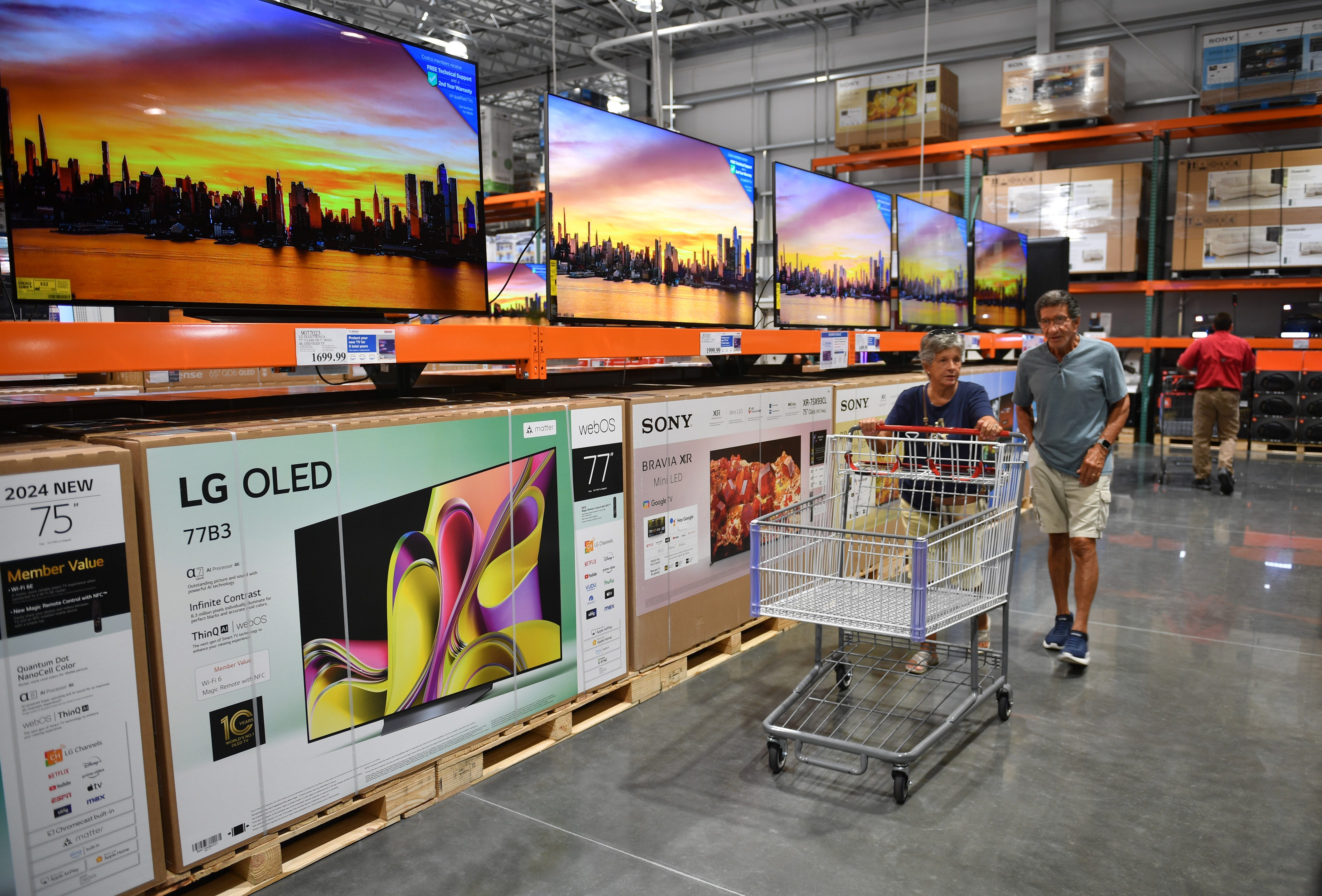 Shoppers make their way past a display of large screen TVs in the electronics department of Costco Wholesale a Costco in North Port, Florida, on June 5, 2024.