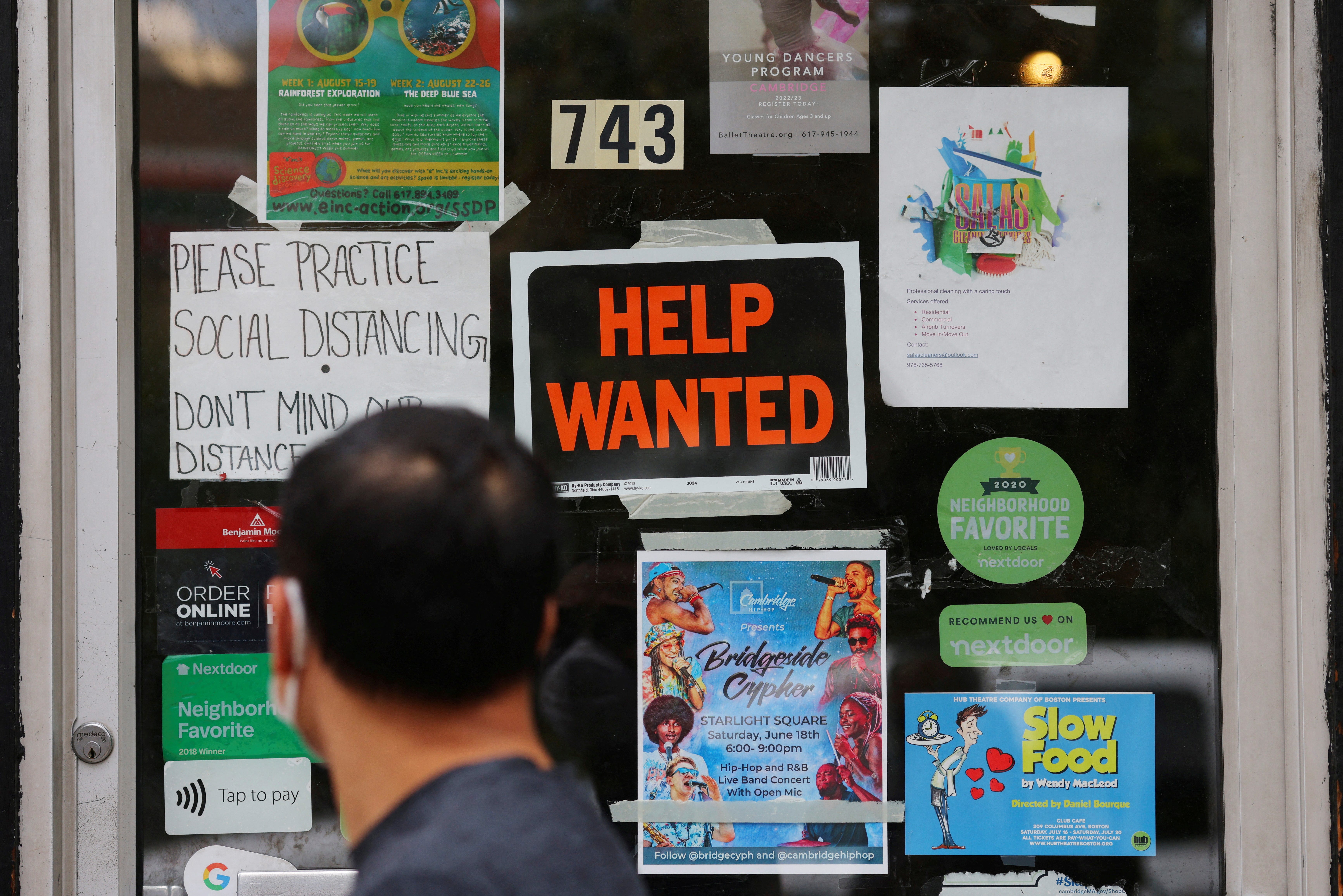 A pedestrian passes a "Help Wanted" sign in the door of a hardware store in Cambridge, Massachusetts, U.S., July 8, 2022. REUTERS/Brian Snyder