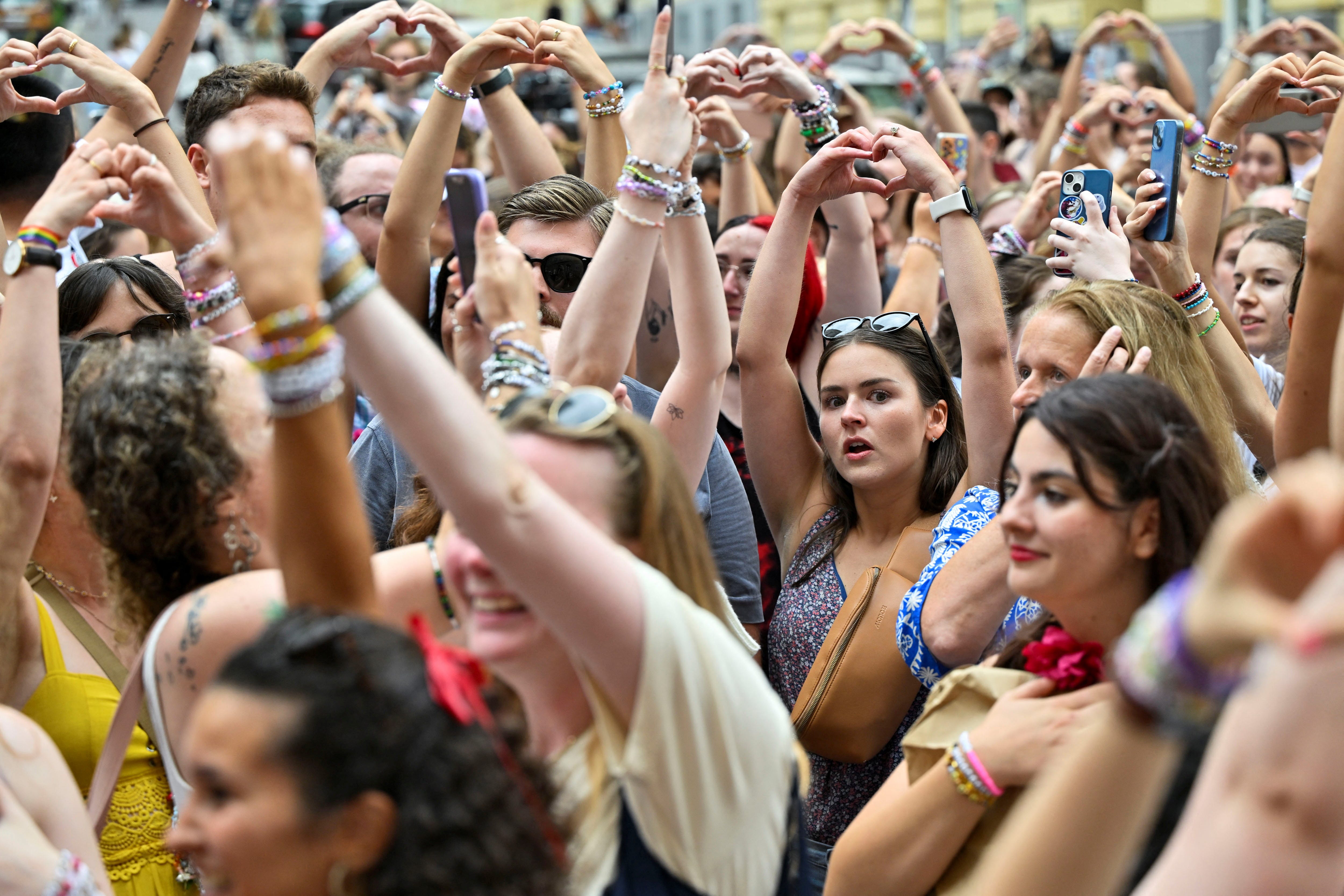 Fans of the singer Taylor Swift make a heart shape with their hands as they gather following the cancellation of three Taylor Swift concerts at Happel stadium after the government confirmed a planned attack at the venue, in Vienna, Austria August 8, 2024. REUTERS/Elisabeth Mandl