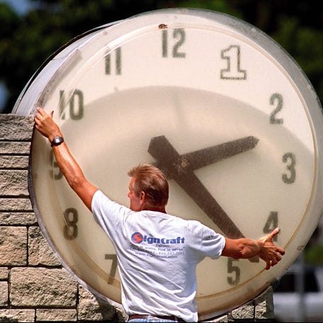 Joe Roskey of Sign Craft of Riviera Beach, works on the outdoor clock at the First Bank of Florida, at the corner of Olive Avenue and Southern Blvd Wednesday afternoon. Roskey had corrected the time on the clock, which was off because of the switch to daylight savings time.