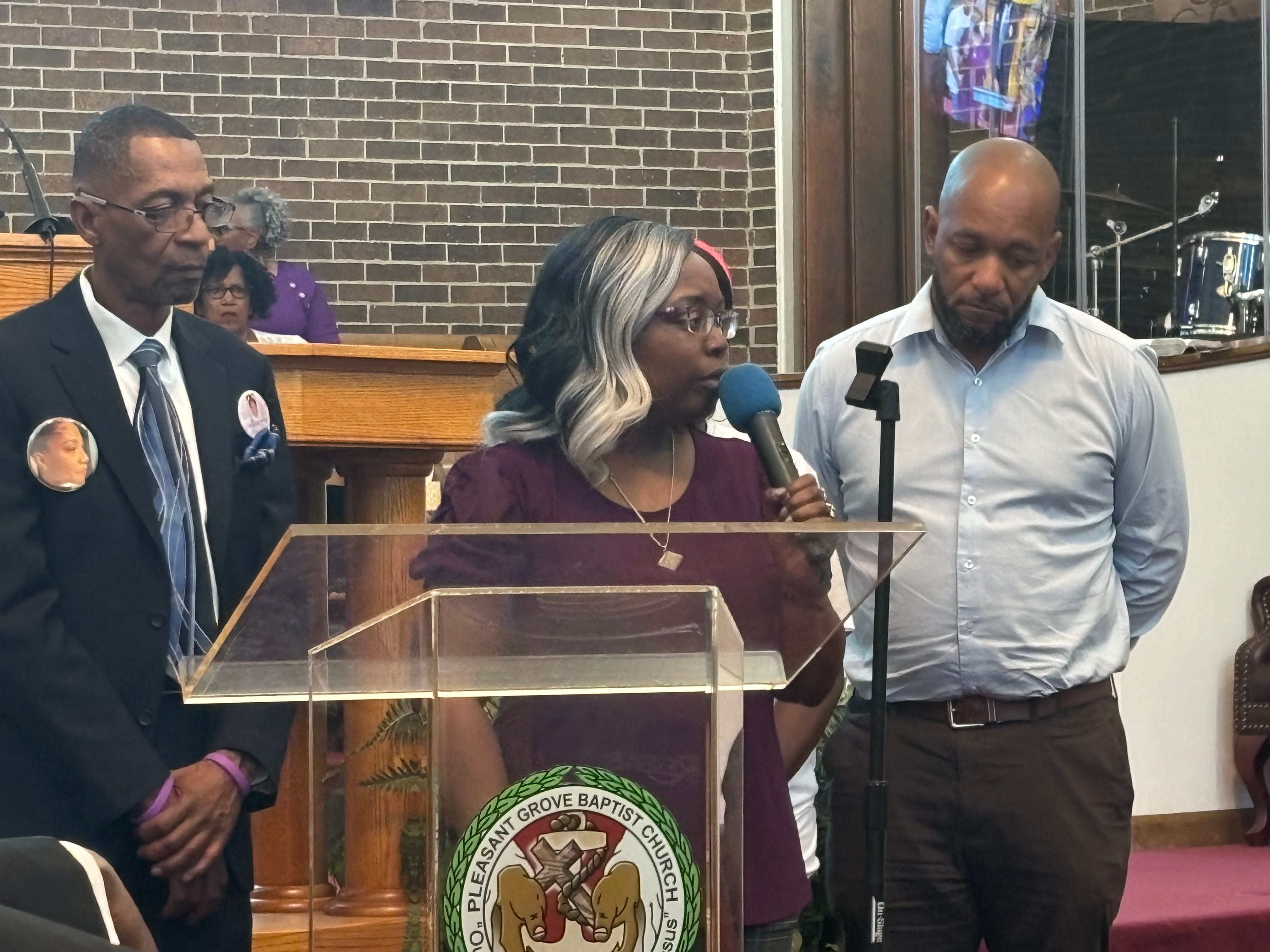 Margaritta Fultz speaks about the Sonya Massey family at a memorial to Massey at the Pleasant Grove Baptist Church on Aug. 14, 2024. At left is Massey's uncle, Raymond Massey, and at right is Sontae Massey, Massey's cousin and Fultz's fiancé.