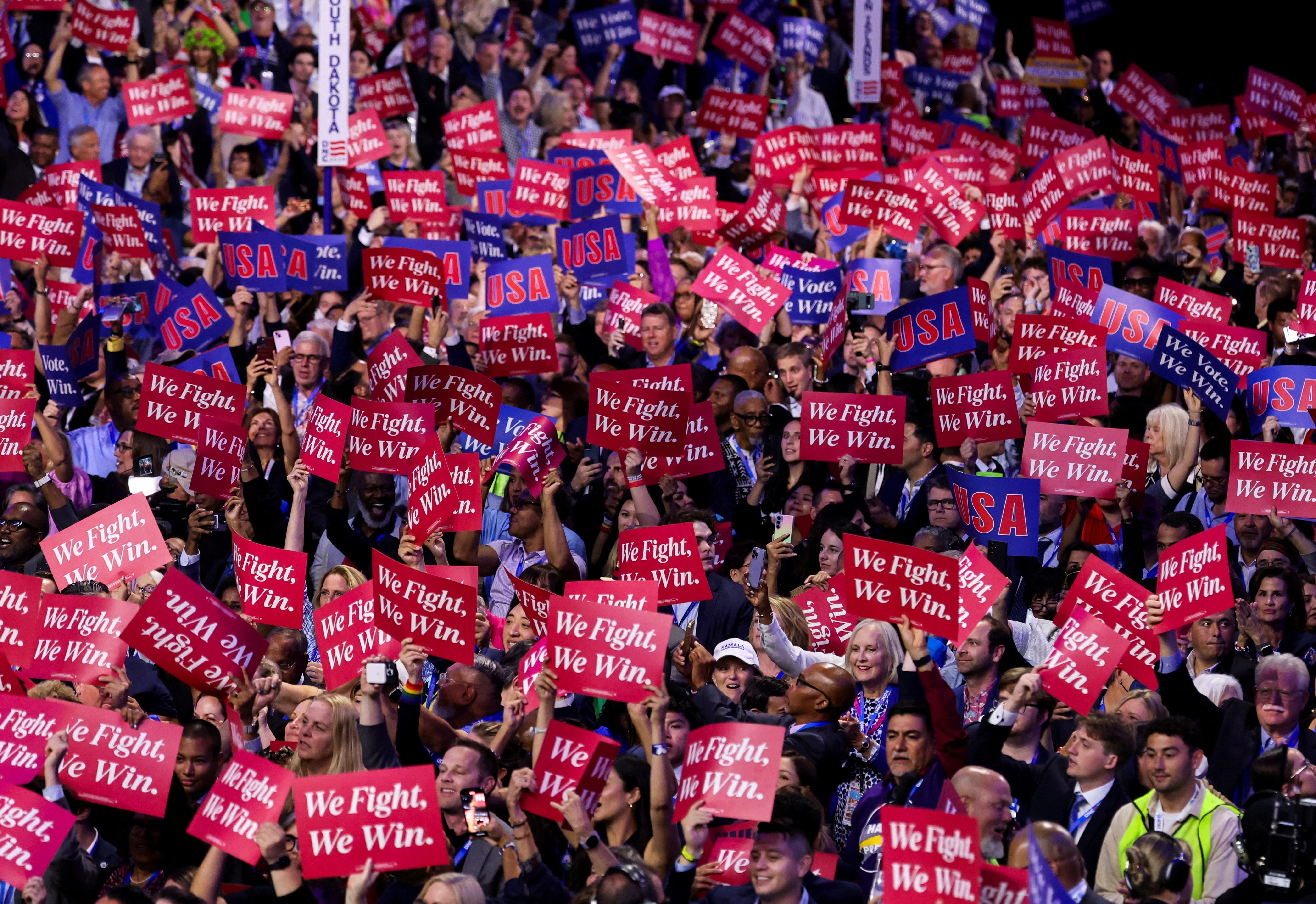 Attendees hold placards as they attend Day one of the Democratic National Convention (DNC) at the United Center in Chicago, Illinois, U.S., August 19, 2024.