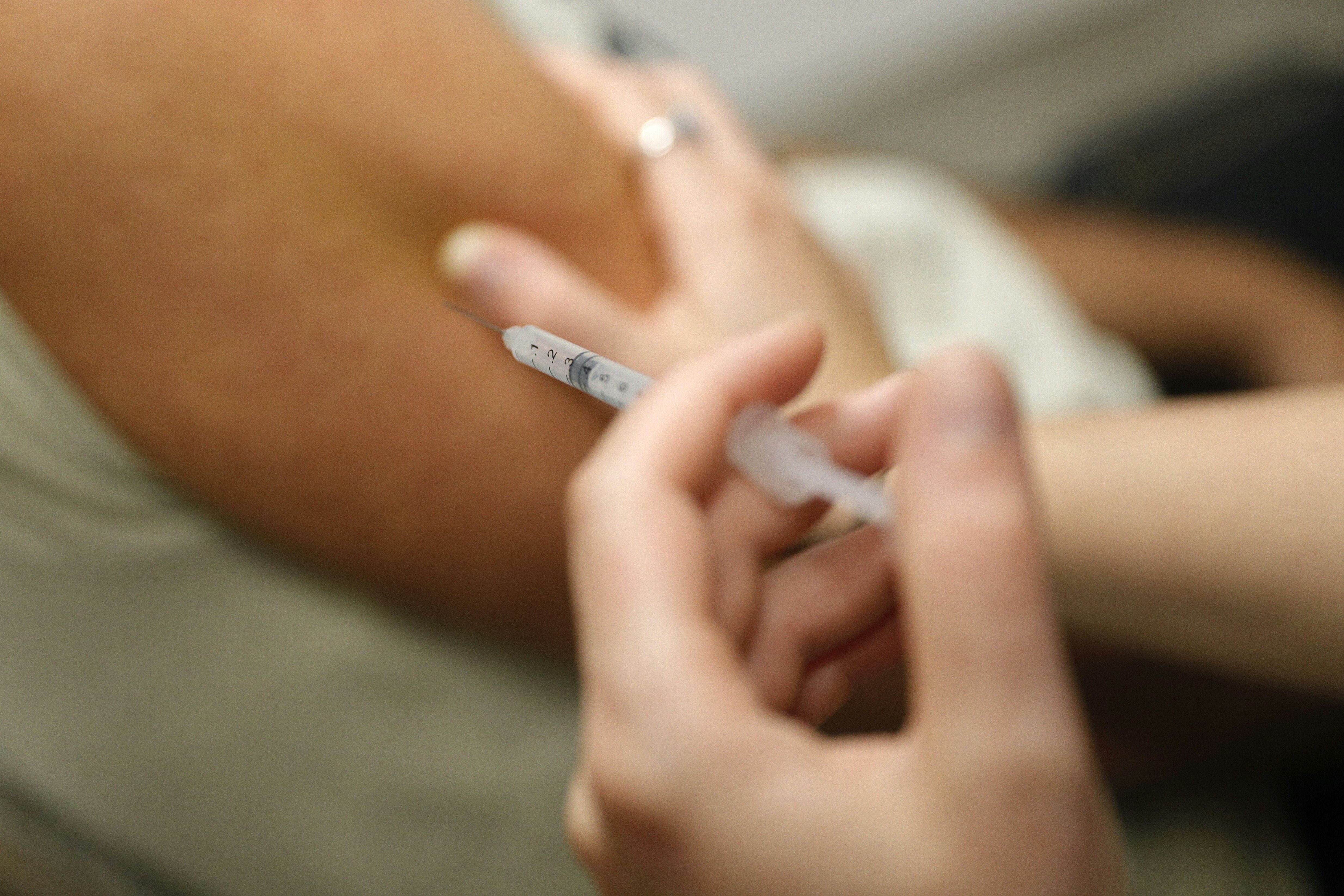 A man receives a dose of Comirnaty Omicron XBB 1.5 Pfizer vaccine for COVID-19 at a pharmacy in Ajaccio, on October 5, 2023, during a new COVID-19 vaccination campagin on the French Mediterranean island of Corsica.