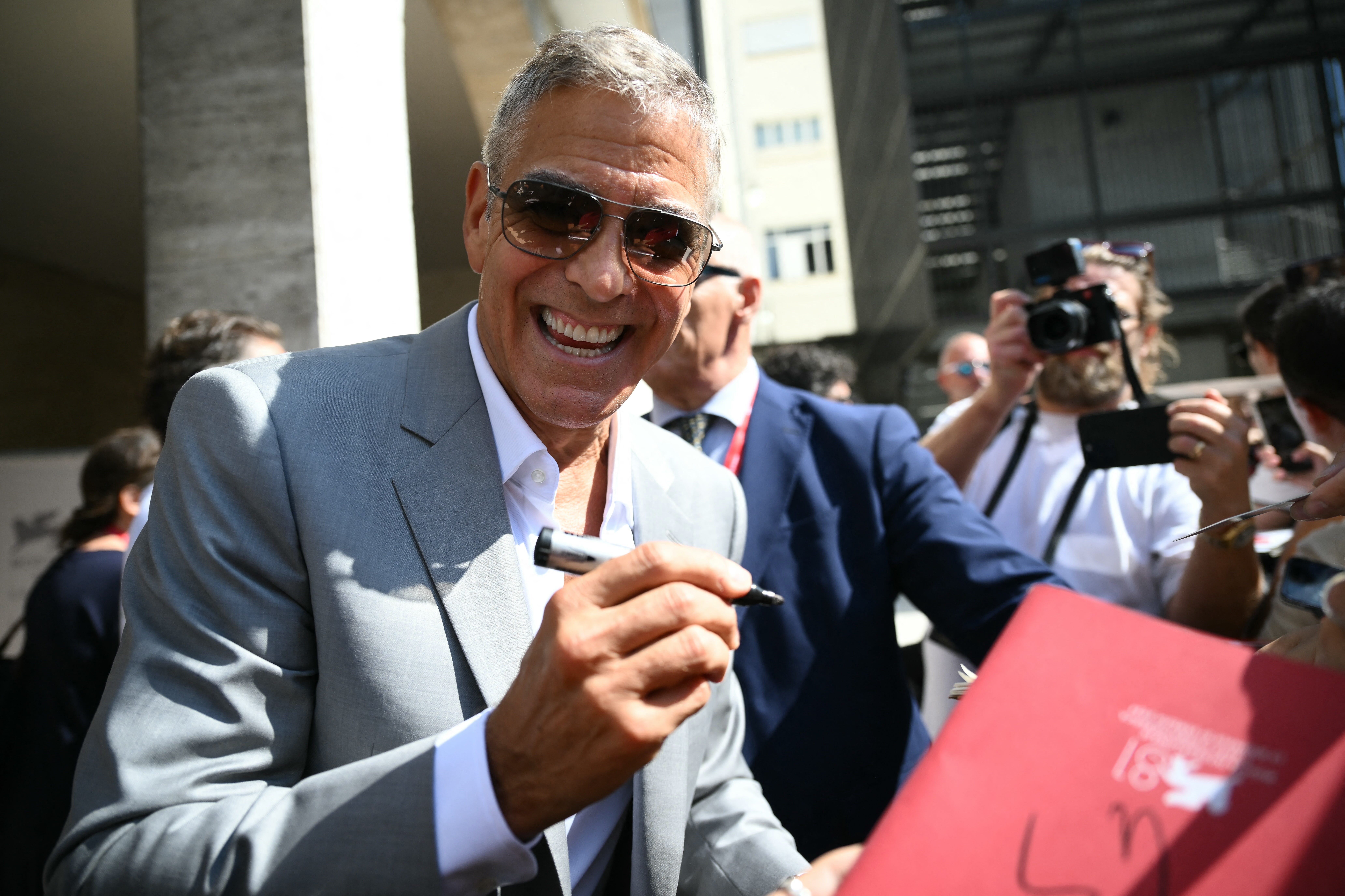 TOPSHOT - Actor George Clooney signs autographs at the Casino pier during the 81st Venice International Film Festival at Venice Lido, on September 1, 2024 . (Photo by Marco BERTORELLO / AFP) (Photo by MARCO BERTORELLO/AFP via Getty Images) ORIG FILE ID: 2169031926