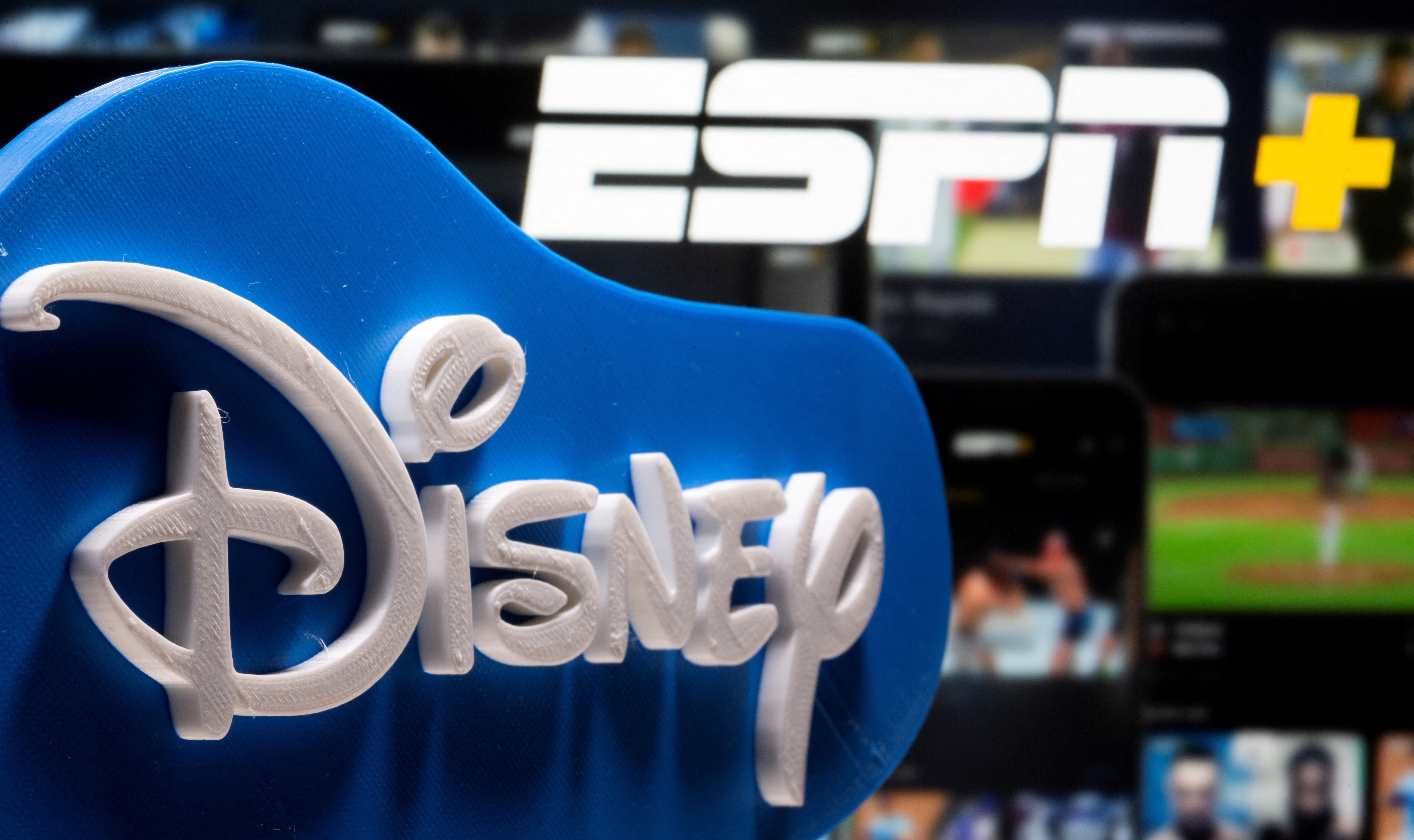 A 3D printed Disney logo is seen in front of the ESPN+ logo in this illustration.